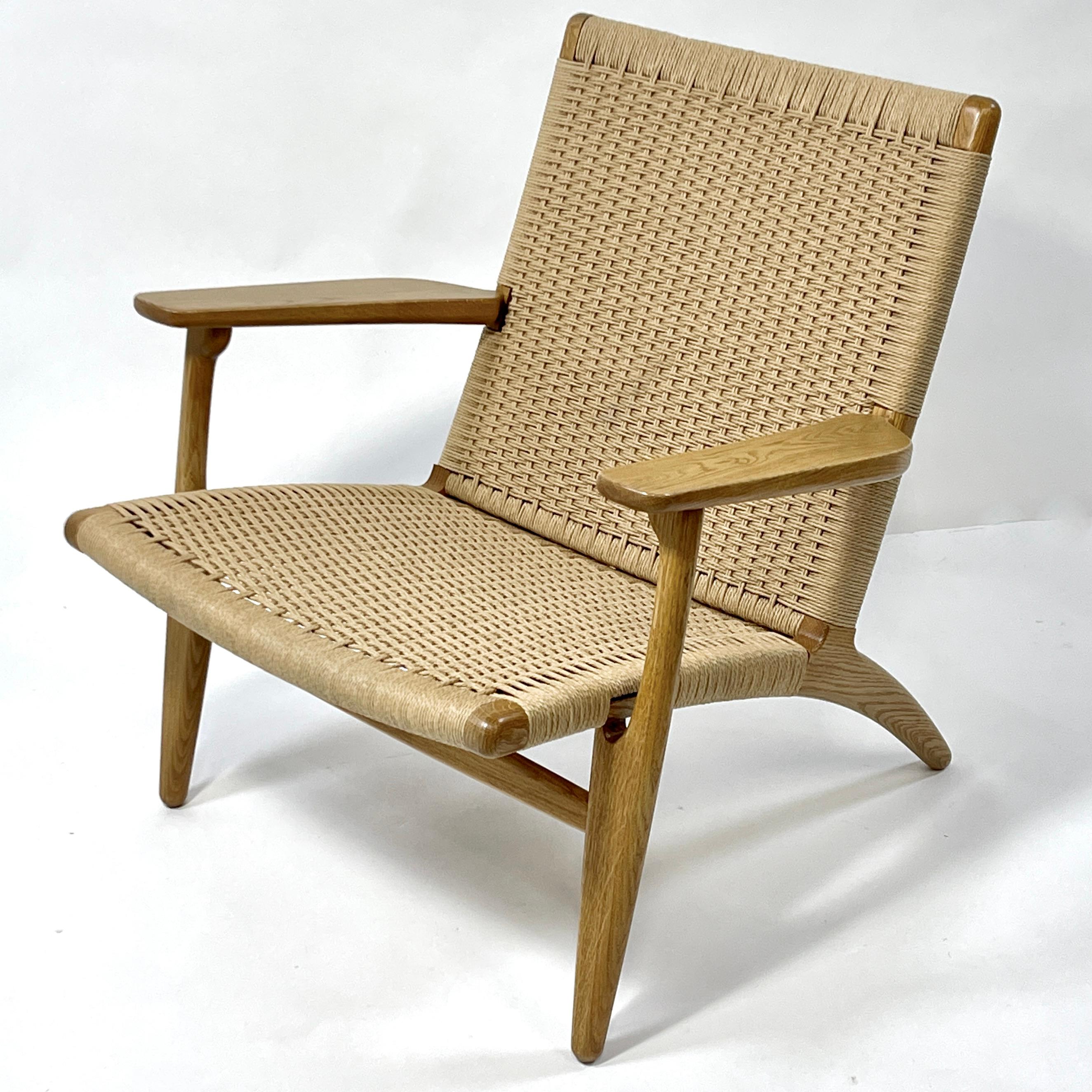 This is an oiled oak and papercord Hans Wegner Model CH25 Lounge chair. Excellent and comfortable. Solid handmake construction. Still being produced and distributed by Carl Hansen and Sons. This is a more recent production from Carl Hansen and Sons.