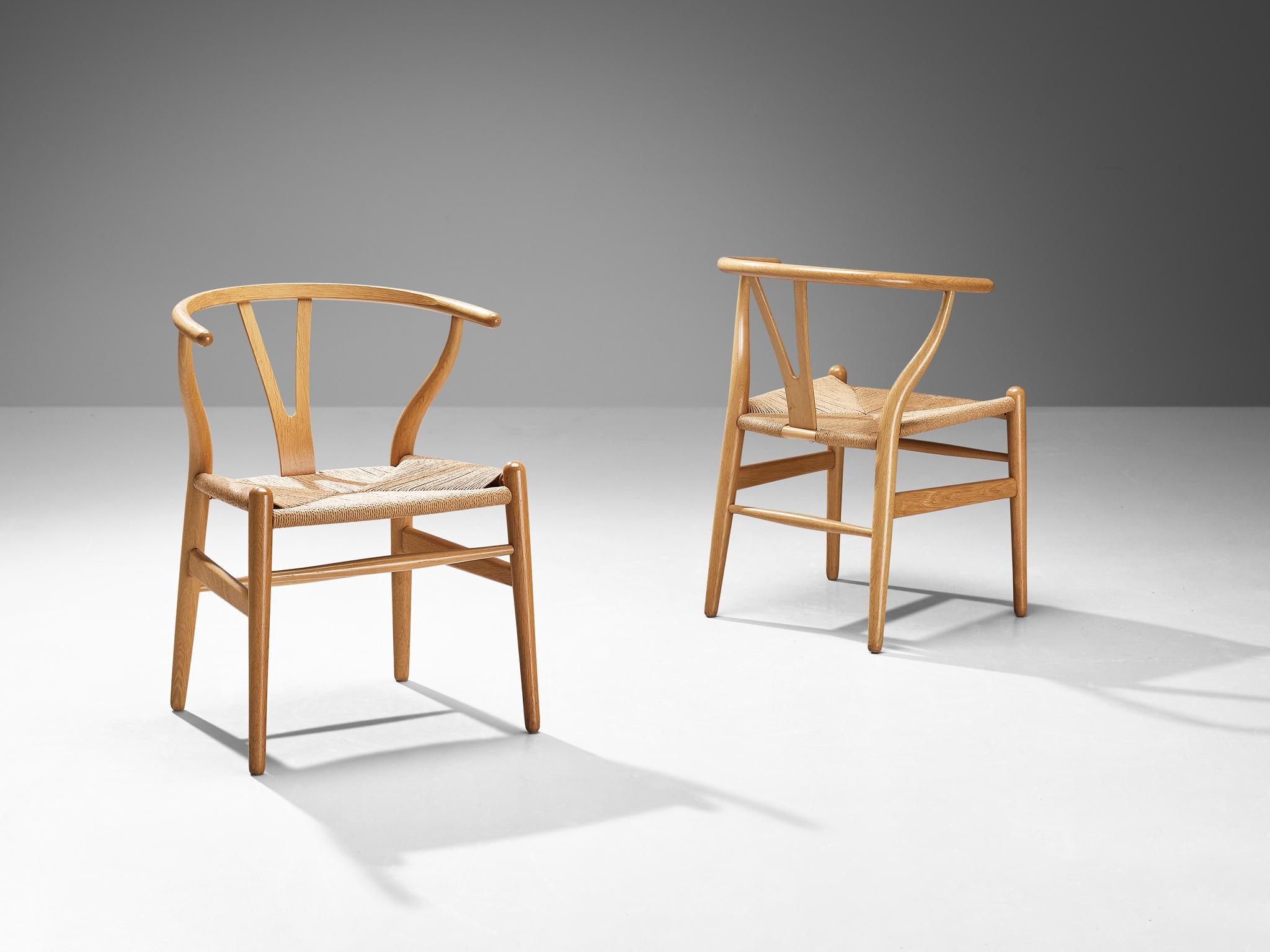 Hans J. Wegner for Carl Hansen & Søn, pair of 'Wishbone' chairs, model 'CH24', oak, papercord, Denmark, design 1950, production afterwards

The Wishbone chair is one of the best known and most celebrated designs of Hans Wegner. A simplistic design
