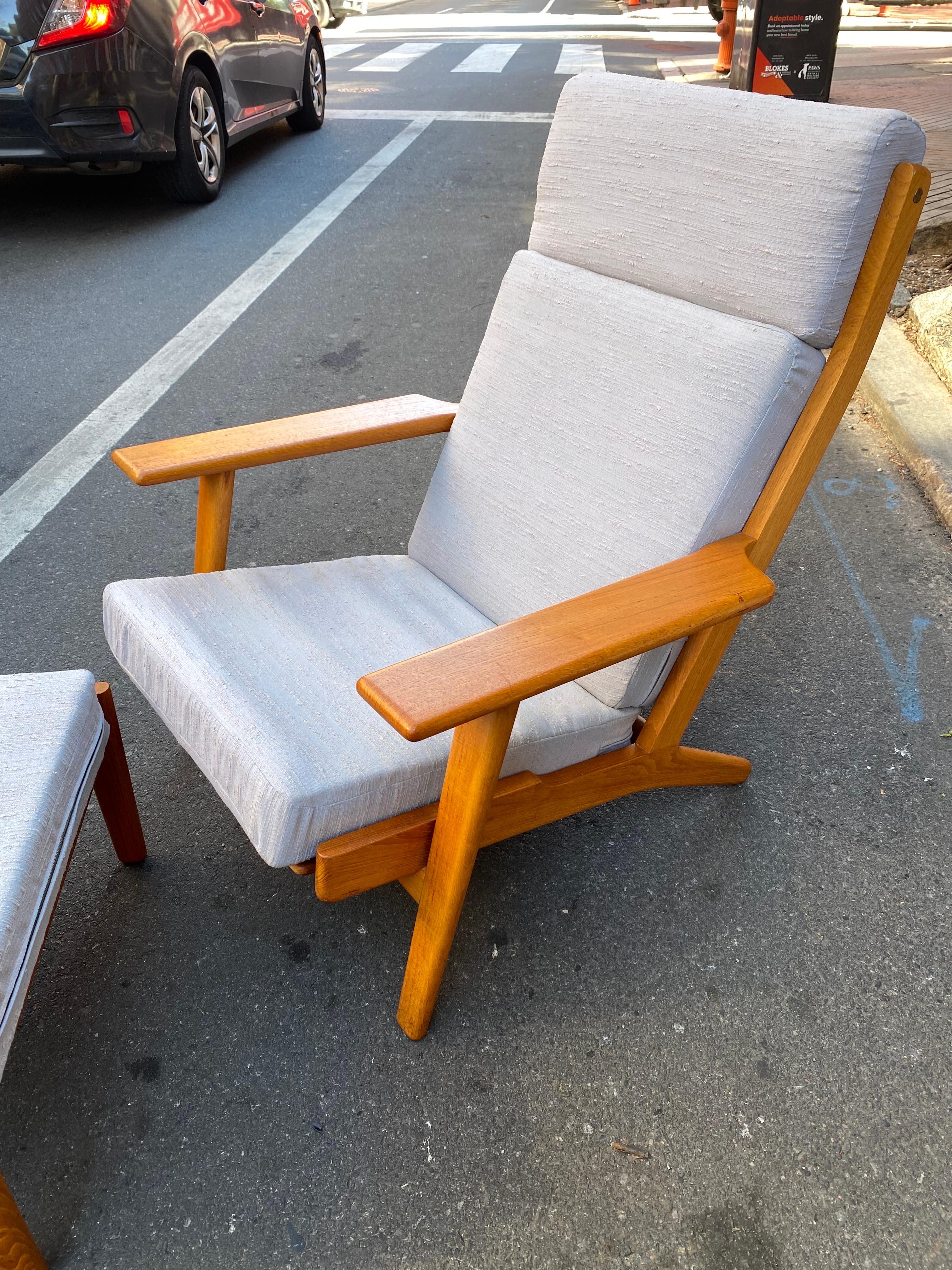 Hans Wegner for Getama High Back Oak Lounge Chaior and Ottoman. Beautiful Wood in Original Condition. Upholstery is clean but could benefit from a redo with more padding to the Original inner wire coil springs. Nice to have with Ottoman! Check out