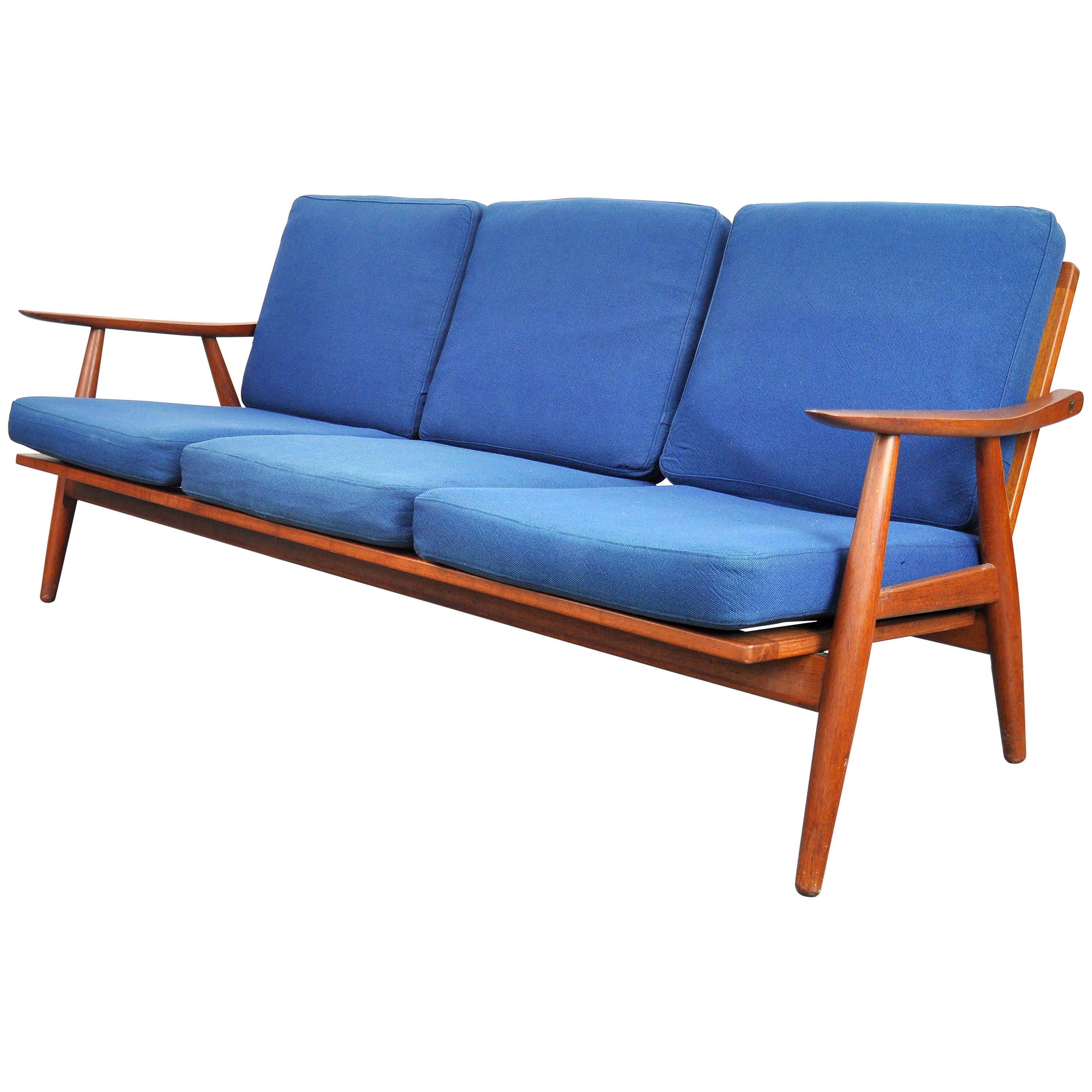 Vintage all original midcentury Danish modern three-seat teak couch, model GE-270, manufactured by GETAMA in Gedsted, Denmark in the 1950s, designed by Hans J. Wegner. The solid teak frame has the original oiled finish and brass hardware. The