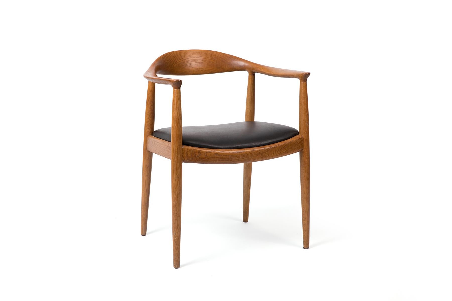 Known as the iconic “Round Chair,” this armchair was designed by Hans Wegner in 1949. The chairs have deep oak frames with black leather seats and bear the Johannes Hansen stamp. Four available.