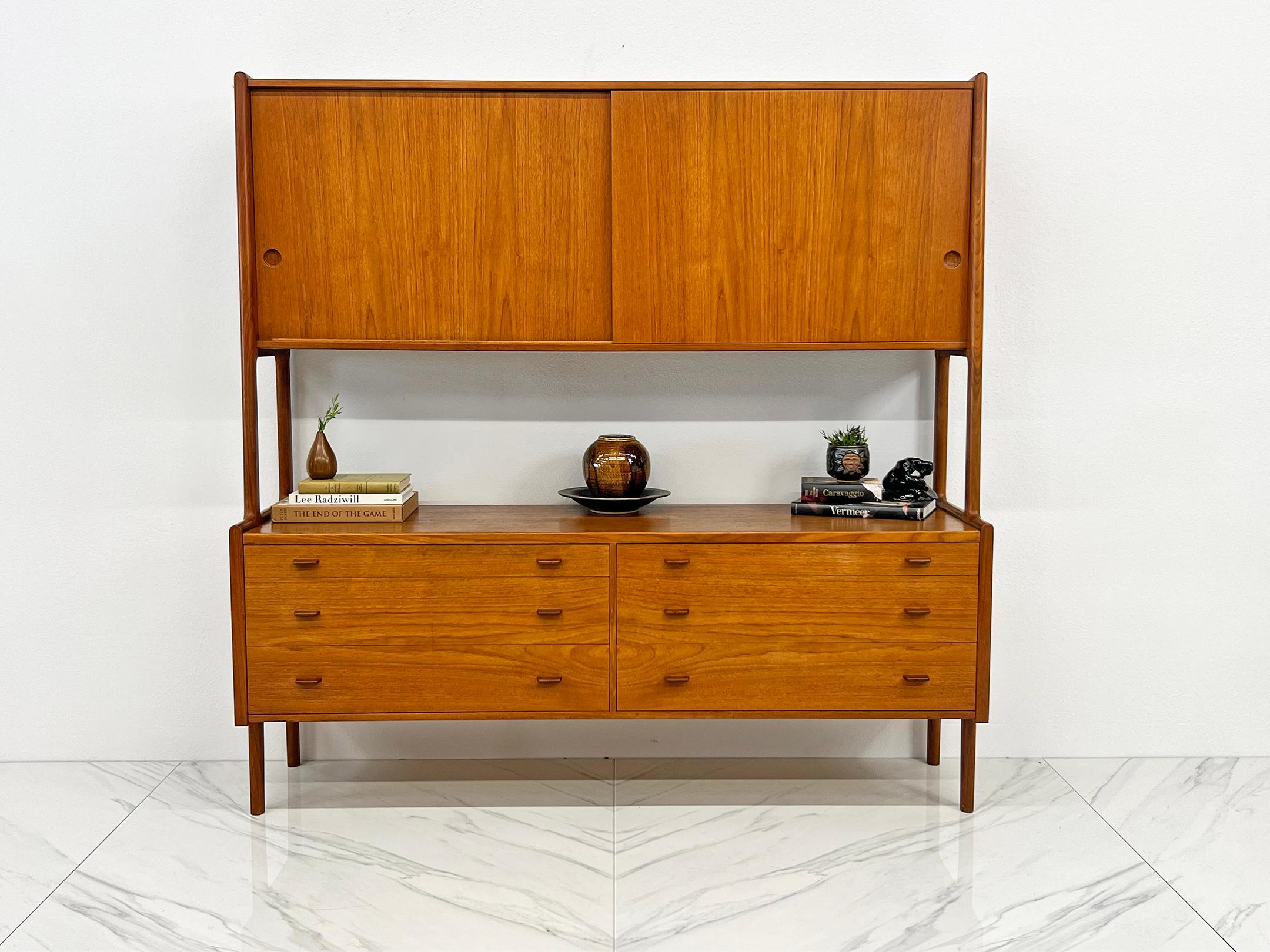 Step into the mid-century magic with this Hans Wegner-designed wall unit from Ry Mobler, a true vintage gem born on April 28, 1958 (it's birthday is stamped on the back of the piece). Crafted in the timeless elegance of teak, this wall unit is yet