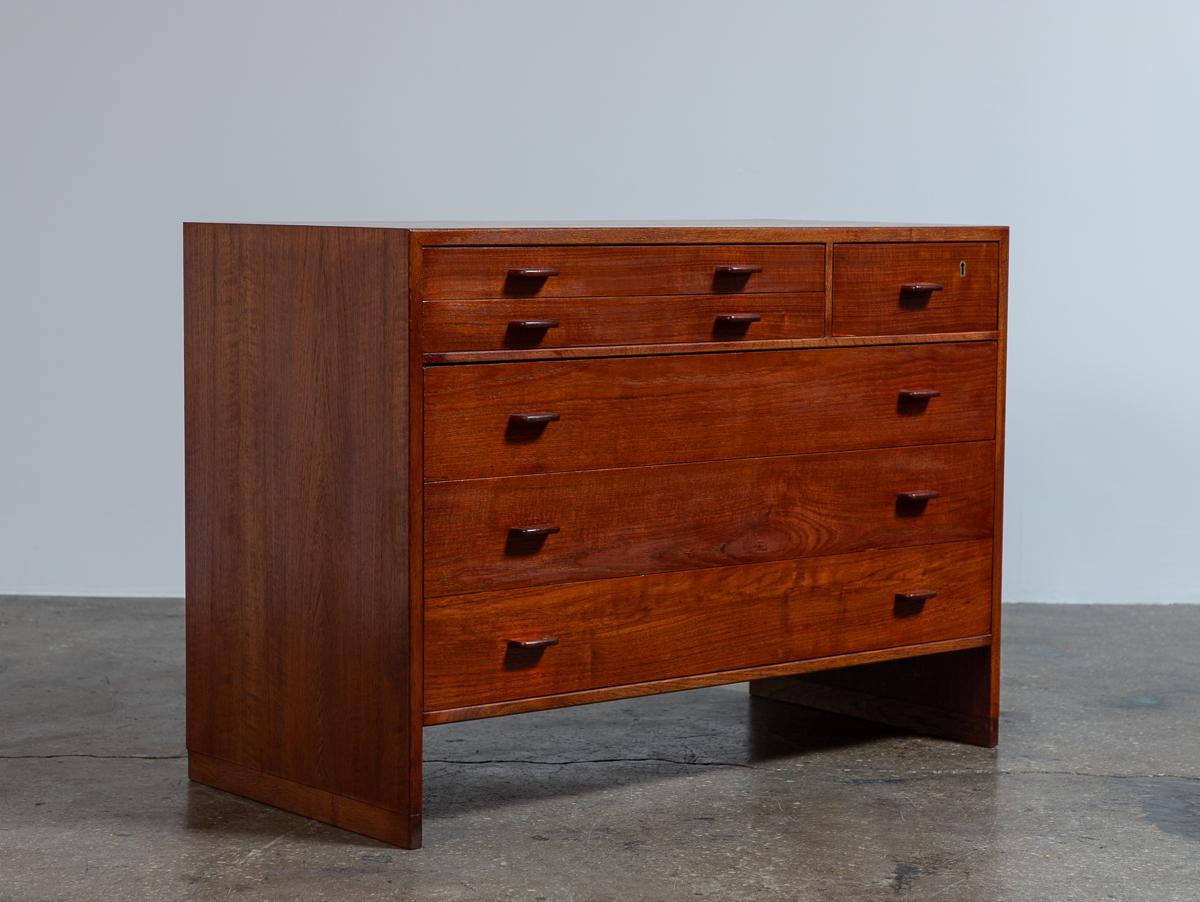 Gorgeous teak and oak chest, designed by Hans Wegner for RY Mobler. A streamlined design, with a square silhouette and contrasting sled base. This chest offers a versatile storage, with a neat set of file drawers and deep drawers. Carved wood pulls