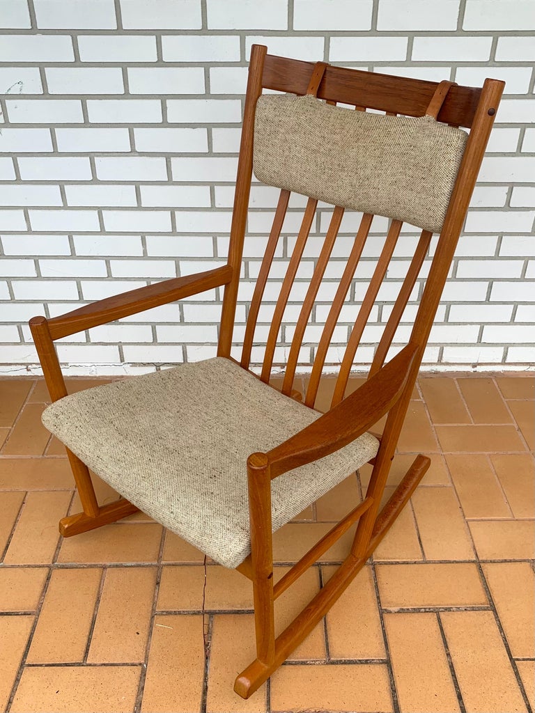 Solid teak rocking chair by Hans Wegner for Tarm Stole OG Mobelfabrik. Made in Denmark and in great vintage condition. Padded seat and a padded headrest held in place by leather straps. Very comfortable and has a good rock. Classic Danish Modern