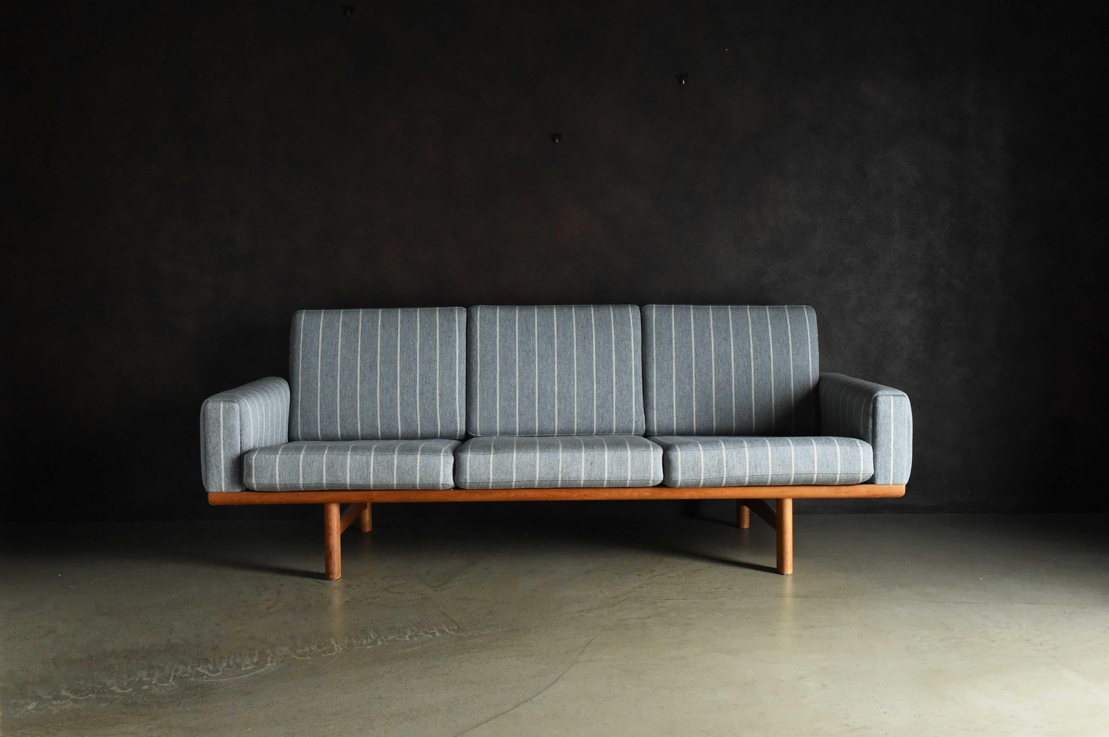 Es handelt sich um ein dreisitziges Sofa des Herstellers GETAMA. Das schlichte Design zeichnet sich durch geradlinige Linien aus, aber die abgewinkelte Sitzfläche und Rückenlehne wurden sorgfältig berechnet, um die Belastung des Körpers und des