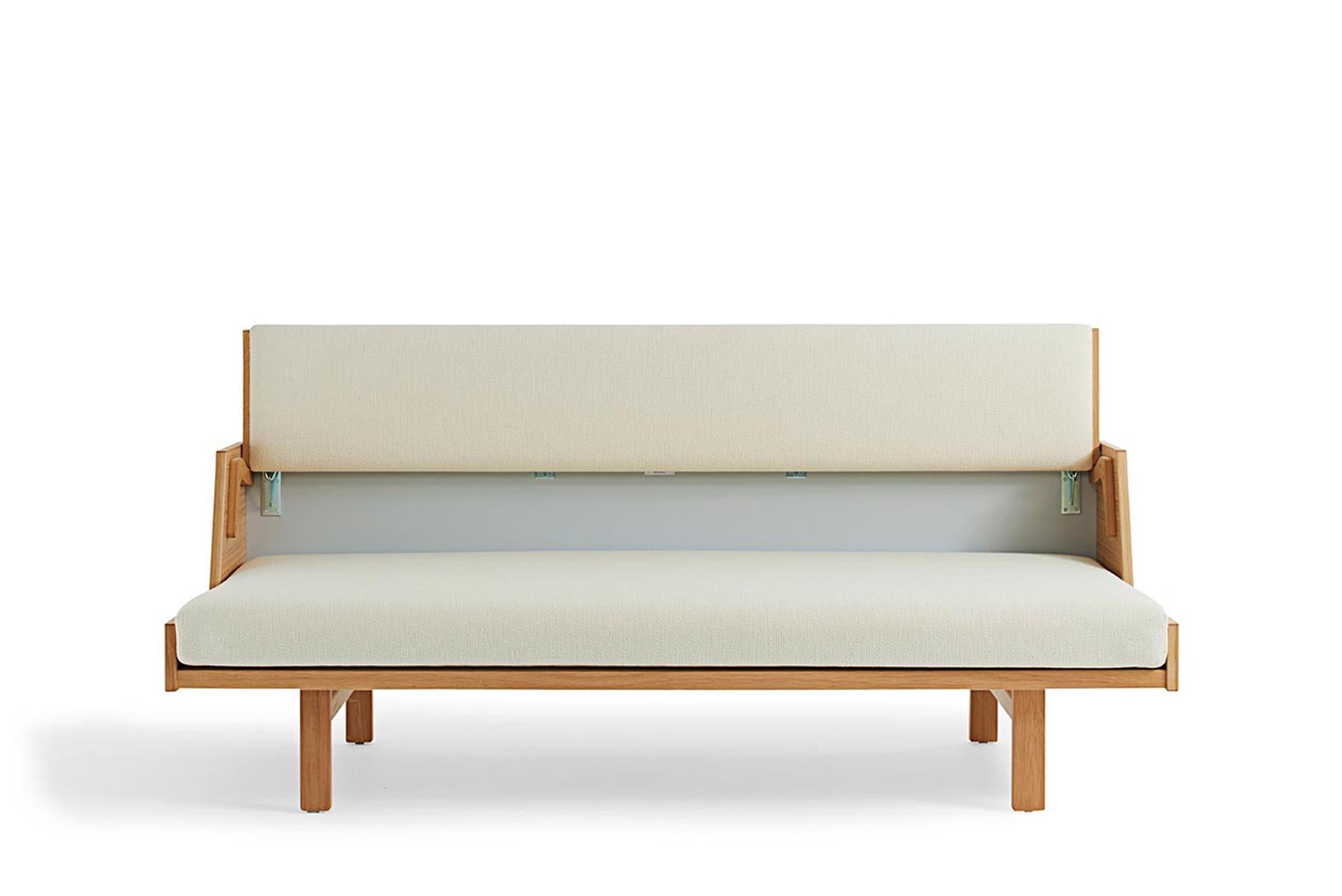 Das 1954 von Hans Wegner entworfene Daybed GE 258 ist ein vielseitiges Möbelstück. Die gepolsterte Rückenlehne lässt sich anheben, um ein geräumiges Bett zu erhalten. Diese Bank aus Massivholz wird in der GETAMA-Fabrik in Gedsted, Dänemark, von
