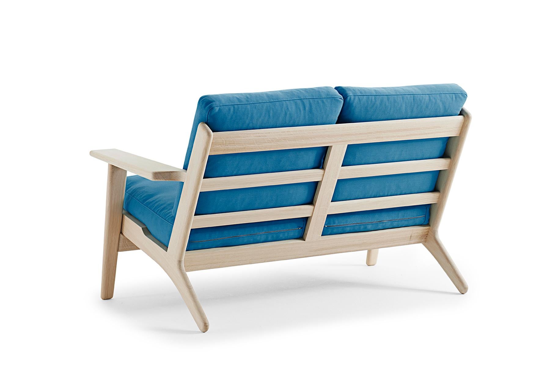 Conçue par Hans Wegner pour Getama en 1953, la GE 290/2 est la version biplace de la chaise longue 290, l'une des œuvres classiques et les plus appréciées de l'architecte. Les grands bras à palettes sculptés mettent en valeur la beauté naturelle du