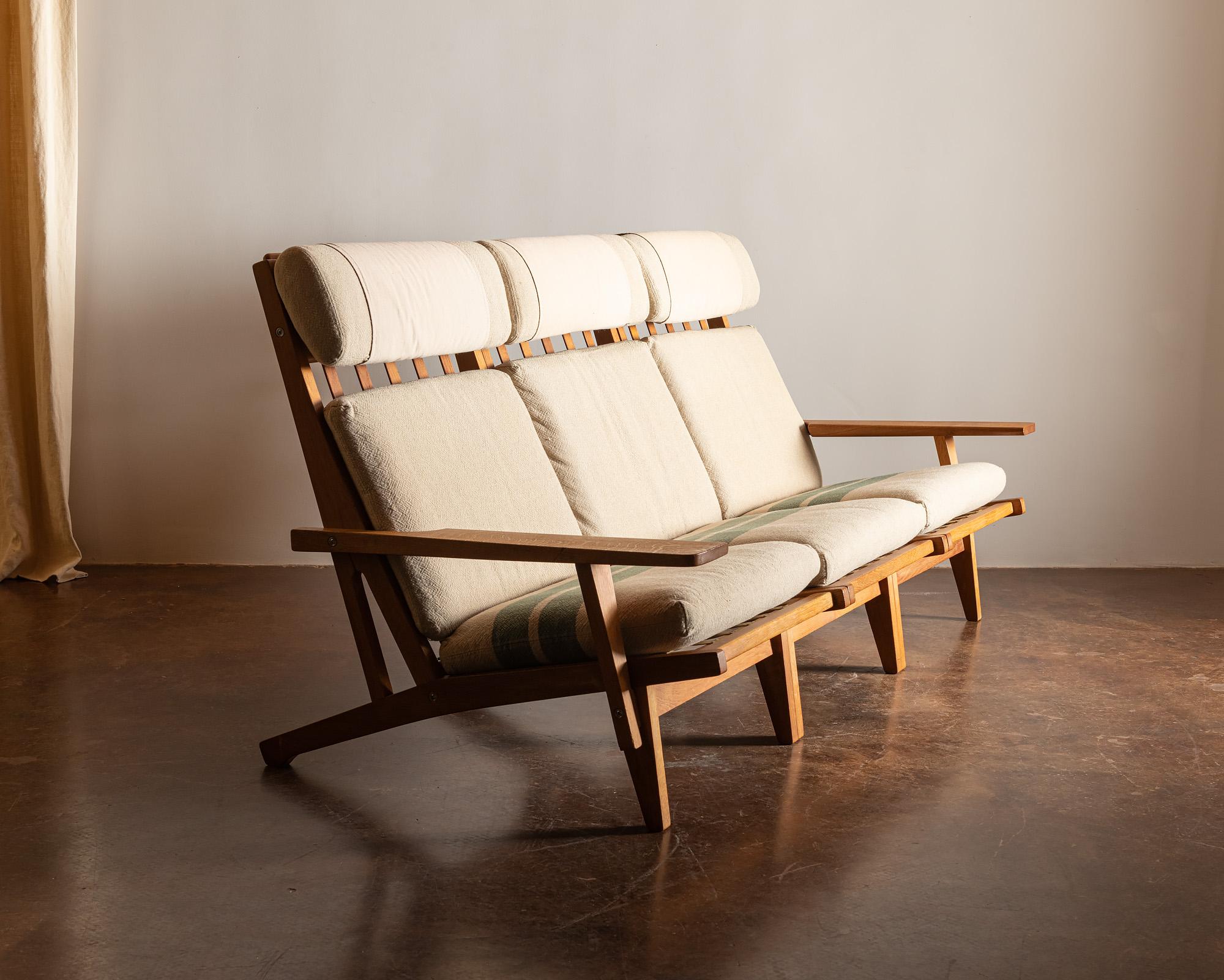 A Classic Wegner GE 375 three-seat in original cotton fabric. Manufactured by Getama, Denmark, 1960s.

The three chairs are separate and can be secured together by the original steel clamps which are visible in the 15th image.