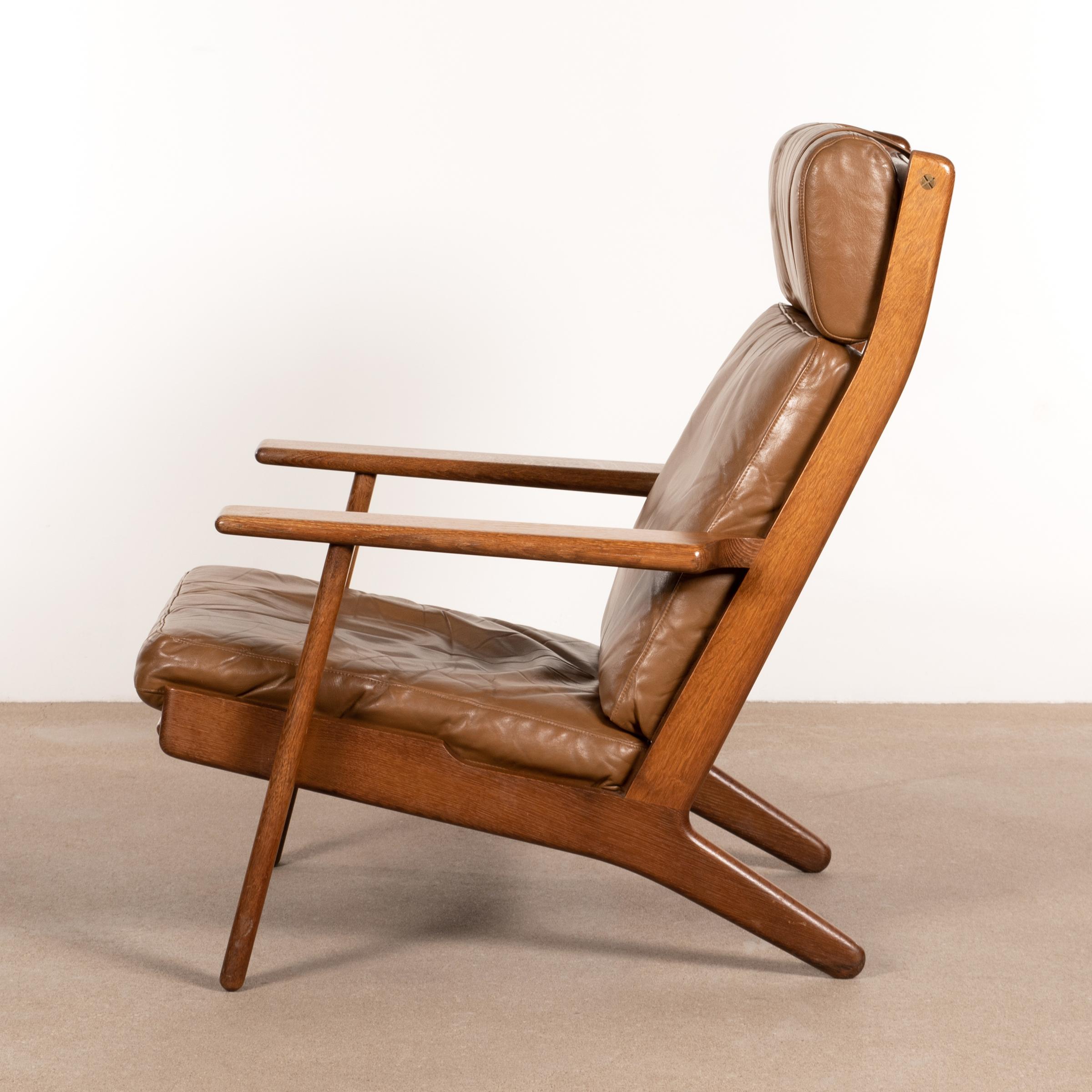 Hans Wegner GE290 lounge high back armchair for GETAMA. Teak varnished frame with brown leather cushions (with patina) in good original condition.