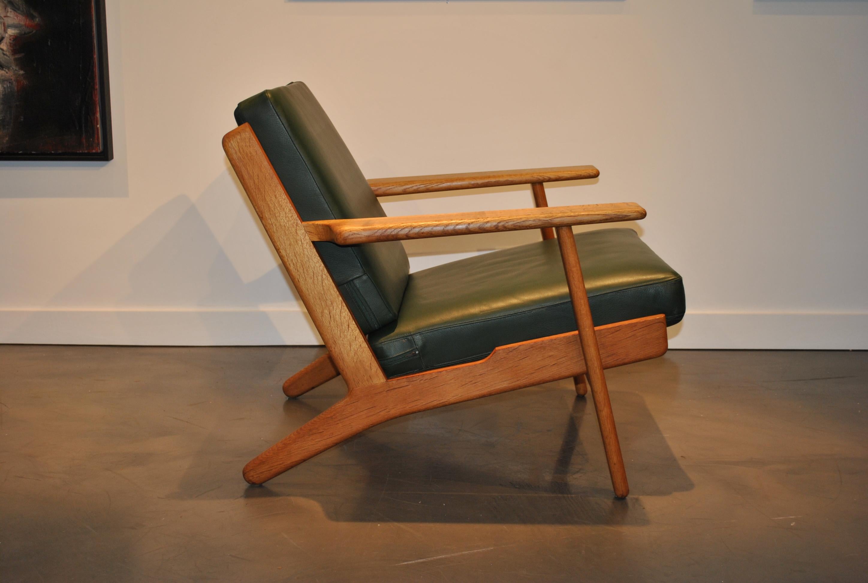 The Classic GE290 lounge chair by Danish master designer Hans J Wegner. These are original 1950s models (several available) from GETAMA, Denmark. Sympathetically refurbished European oak frames with this particular one in dark green leather