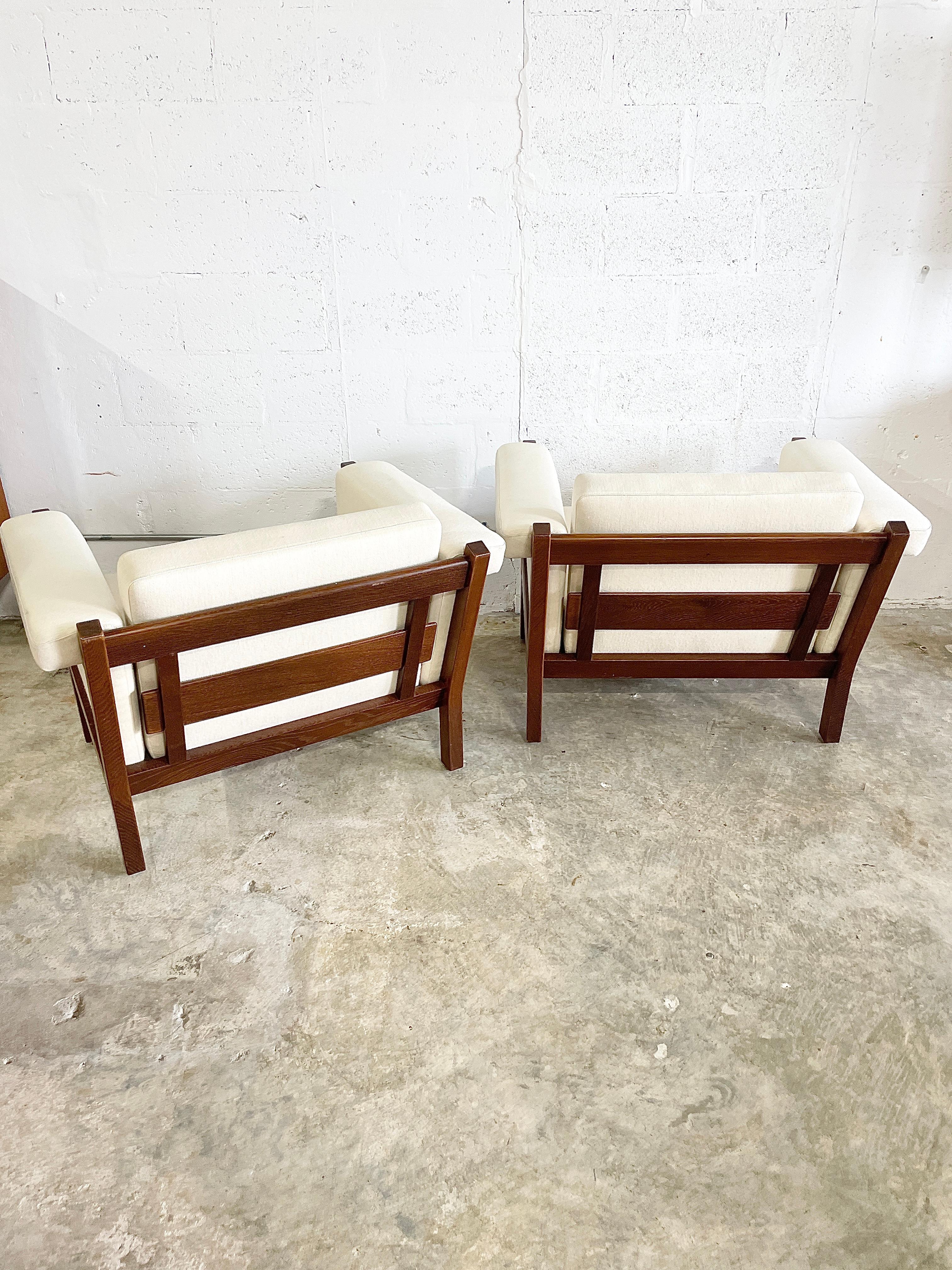 Stained oak-framed Pair of Lounge Chairs designed by Hans J. Wegner for Getama (Denmark). Features light wool upholstery and sprung cushions. Price for pair. 36w 30d 29h 18seat