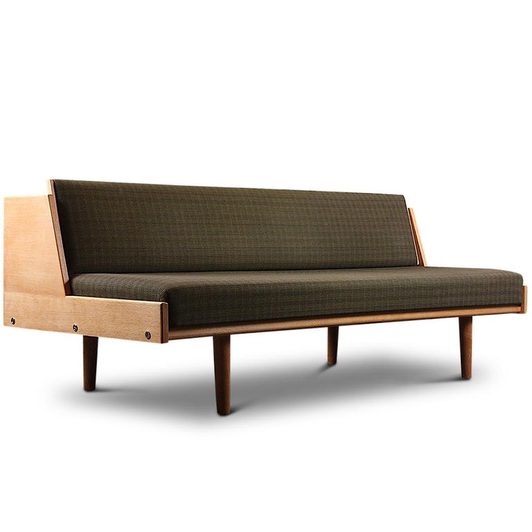 A cleverly designed sofa which converts to a guest bed, and one of most iconic daybed designs of the era: the model GE6 Daybed designed by Hans J. Wegner for Getama. This brilliantly conceived sofa doubles as a single bed when the backrest is