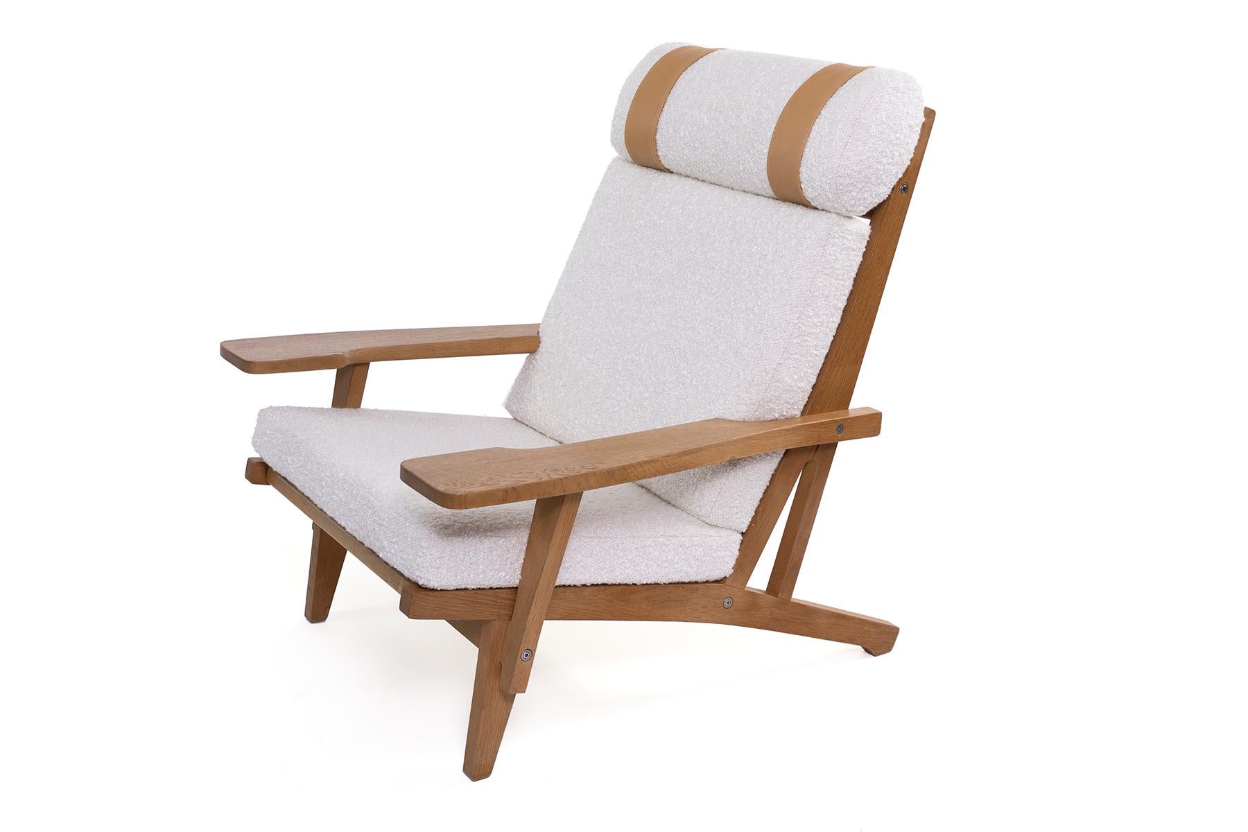 Two Hans J. Wegner for GETAMA wide arm lounge chairs & ottomans in white Turkish bouclé with soft leather accents on the head cushion. Official stamp on the bottom of each chair. Accompanying ottoman measures: 25.5