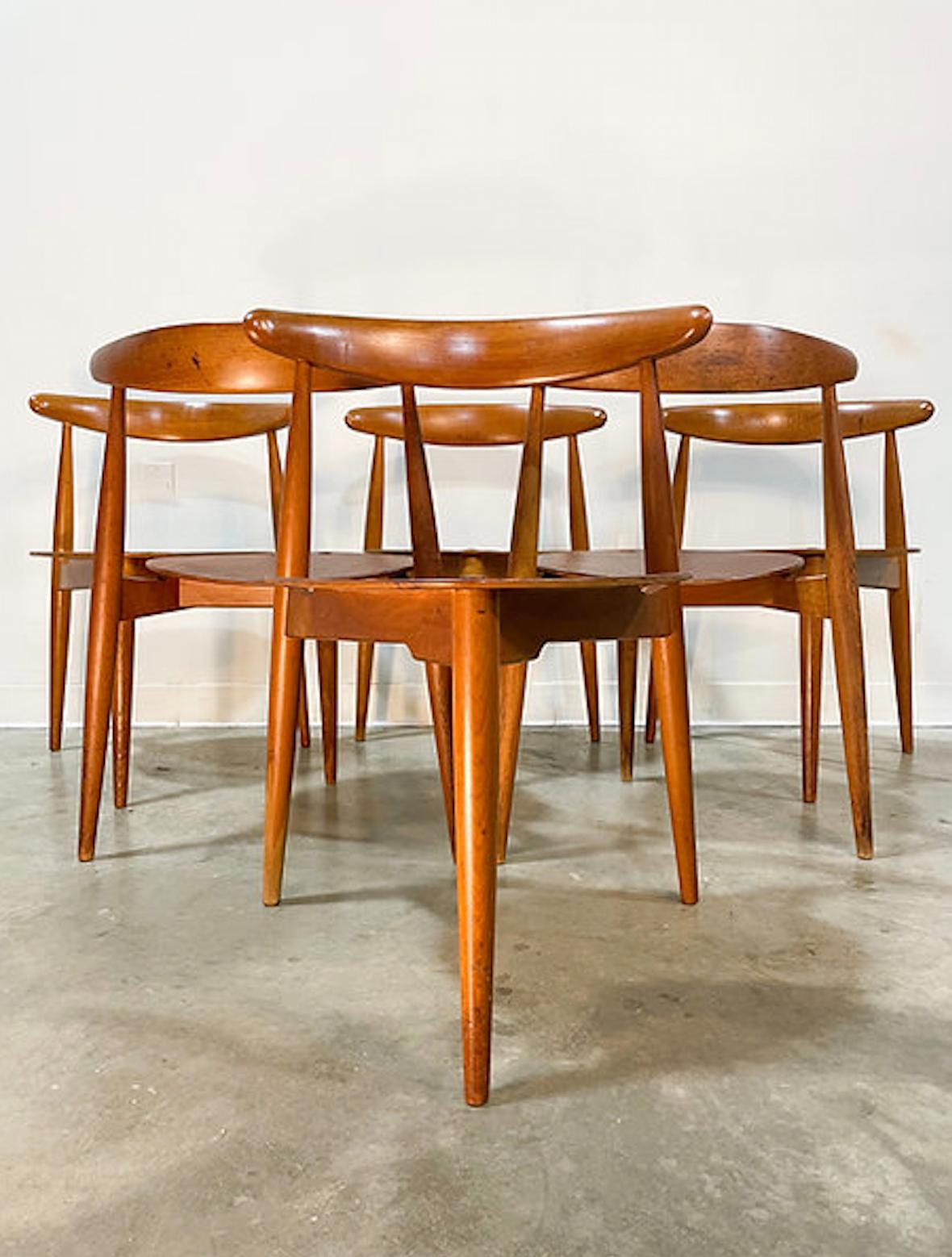 Beautiful set of six 'Heart' chairs (Model FH4103) in teak and beech designed by Hans Wegner and made by Fritz Hansen in the 1950s. Solid beech frames with sculpted backs and three legs paired with a beautiful teak heart-shaped plywood seat make