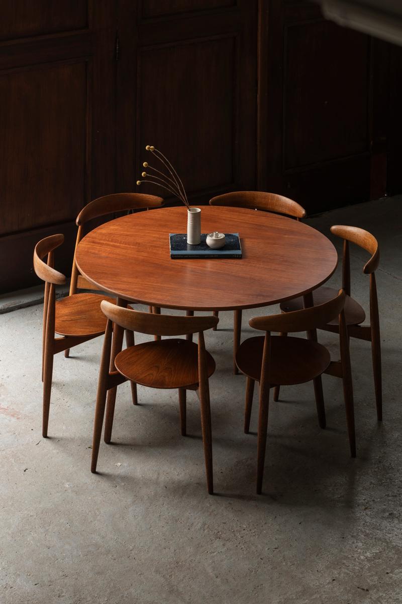 Rare ‘Heart’ Dining set, designed by Hans Wegner and produced by Fritz Hansen in Denmark in the 1950’s. The chairs ‘model FH4103’, are a combination of solid oak and teak veneer. The three-legged round table ‘model FH4602’ has solid oak legs and a