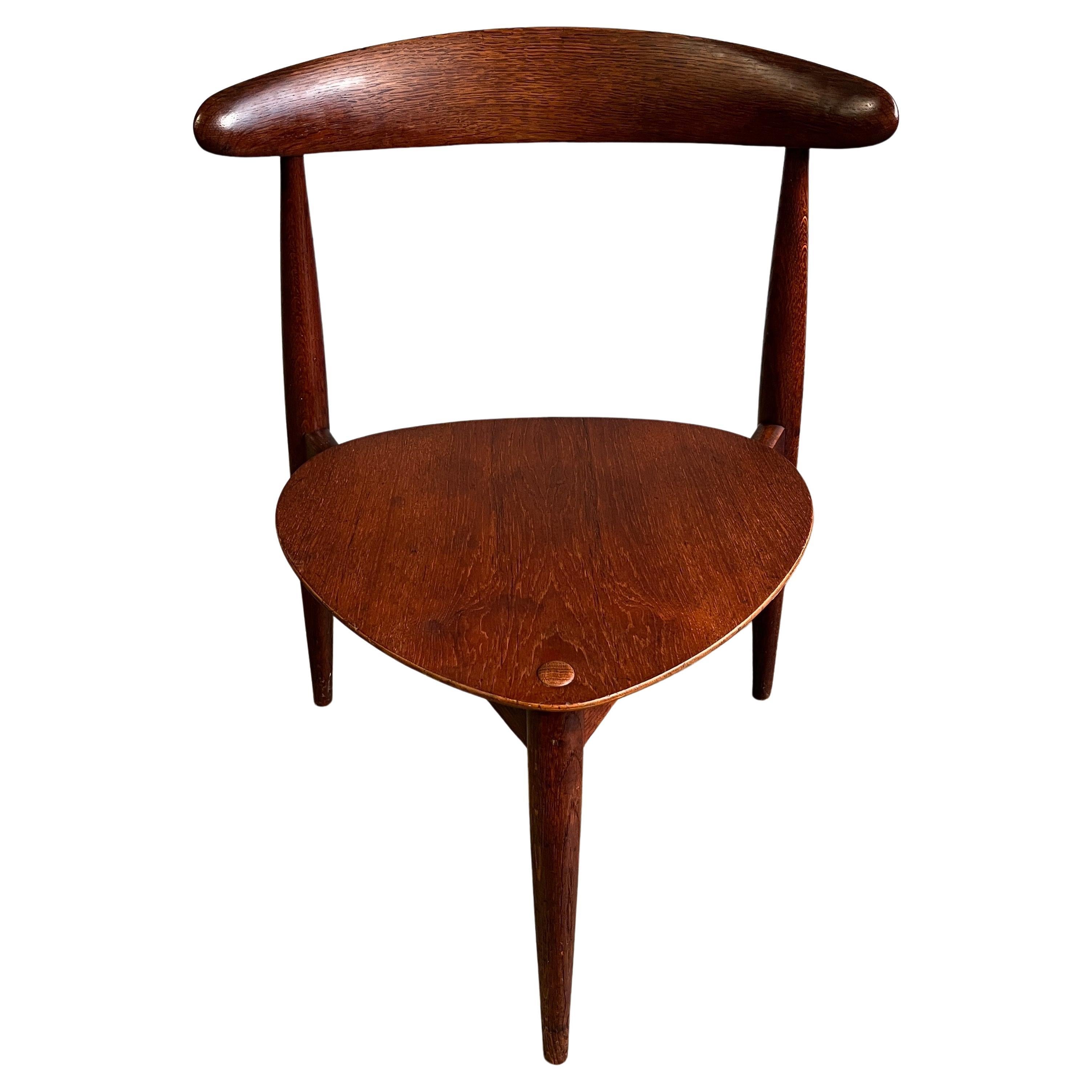 Beautiful side or dining chair designed by Hans Wegner. Having gorgeous original patina with splendid craftsmanship while utilizing a space saving design. Heart three legged chairs, Produced by Fritz Hansen, model FH 4103.   Signs of natural patina.