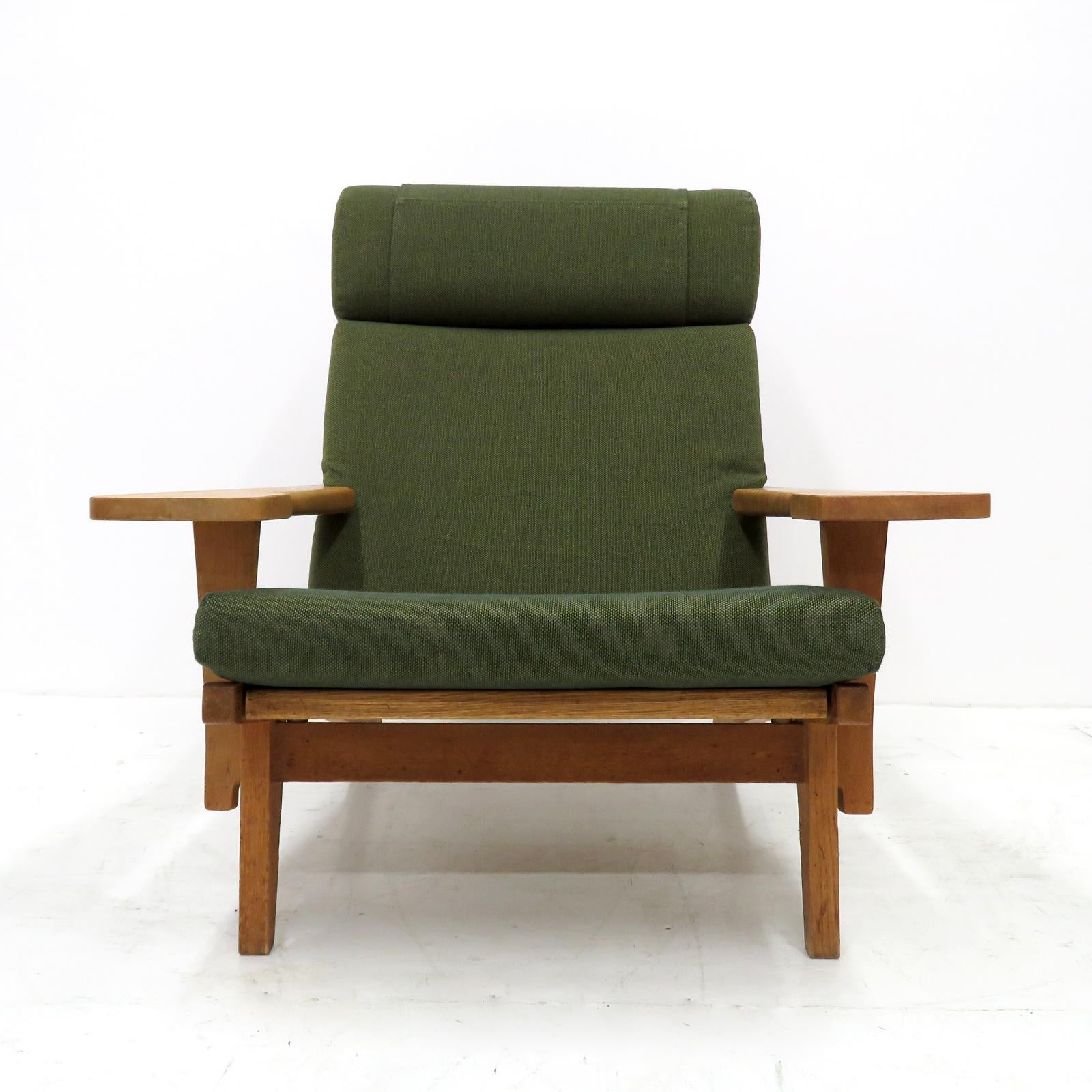 Large-scale high back armchair by Hans Wegner with solid oak frame and original cushions in greenish wool, produced by GETAMA in 1969, model GE 375, detachable neck cushion, original makers mark to underside.
