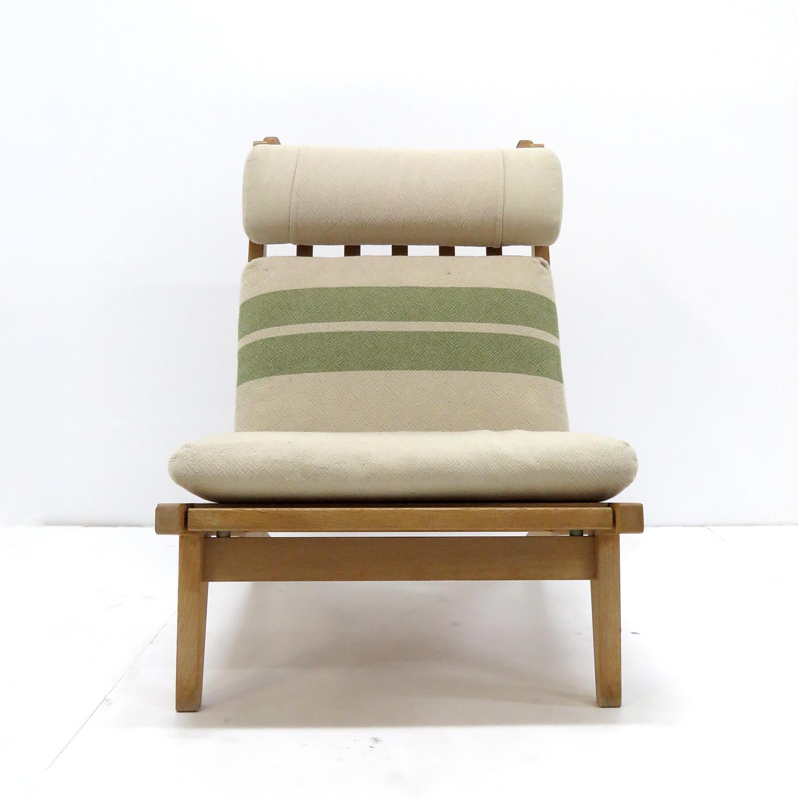 Large scale high back chair by Hans Wegner with solid oak frame and original cushions in beige/greenish striped wool, produced by GETAMA in 1969, model GE 375, detachable neck cushion, original makers mark to underside.
