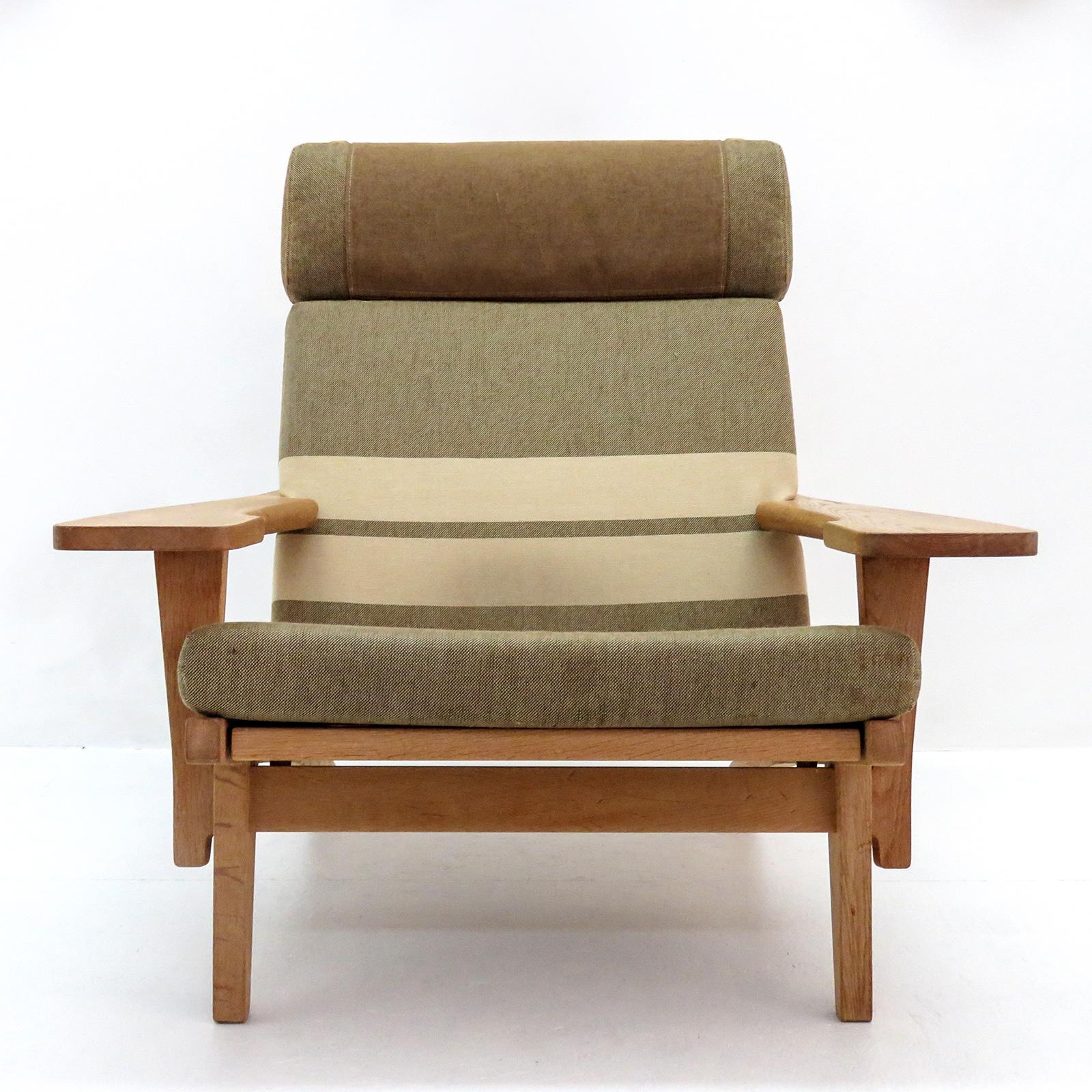 Large-scale high back armchair by Hans Wegner with solid oak frame and original cushions in greenish striped wool, produced by GETAMA in 1969, model GE 375, detachable neck cushion, original makers mark to underside.