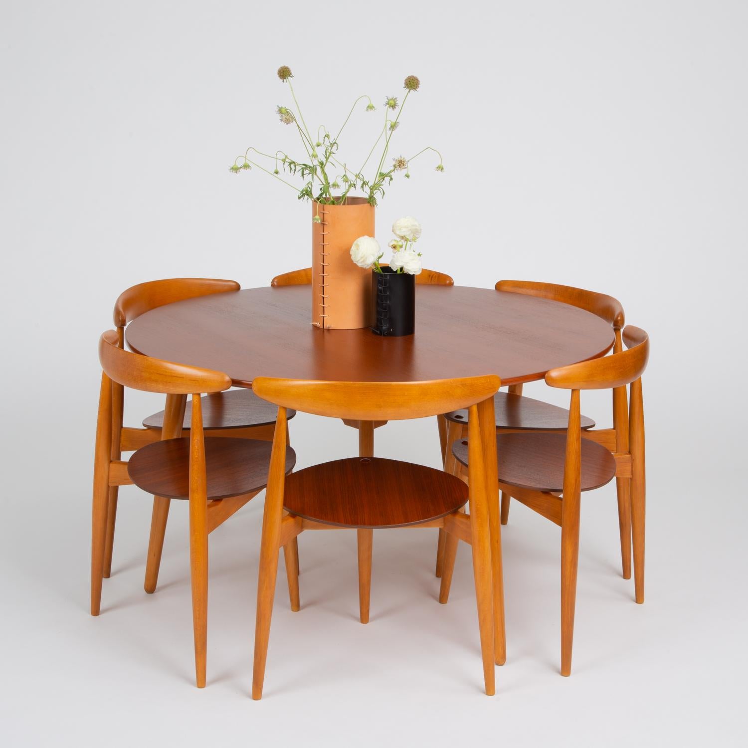 Hans Wegner’s efficient dining set for Fritz Hansen in 1952 comprises a round table with three legs and six three-legged chairs with roughly heart-shaped seats. The unique shapes of the seats and the tripod legs of the table allow all seating to fit