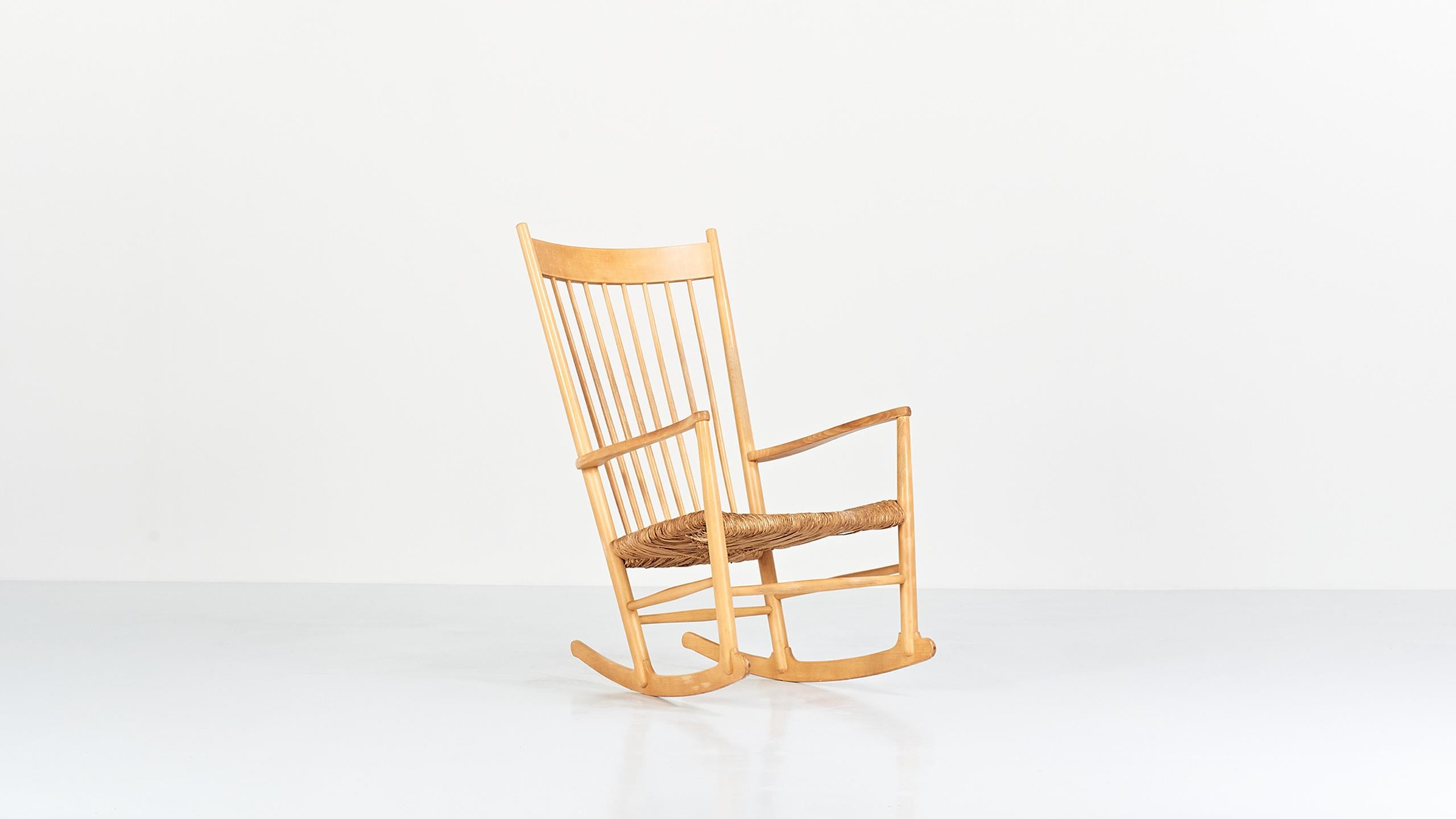 Scandinavian rocking chair in beech, model J16, by Danish designer Hans Wegner for FDB Møbler. Rare in its straw seat version. 

Traces of use and patina of time as showed in pictures, good general condition.