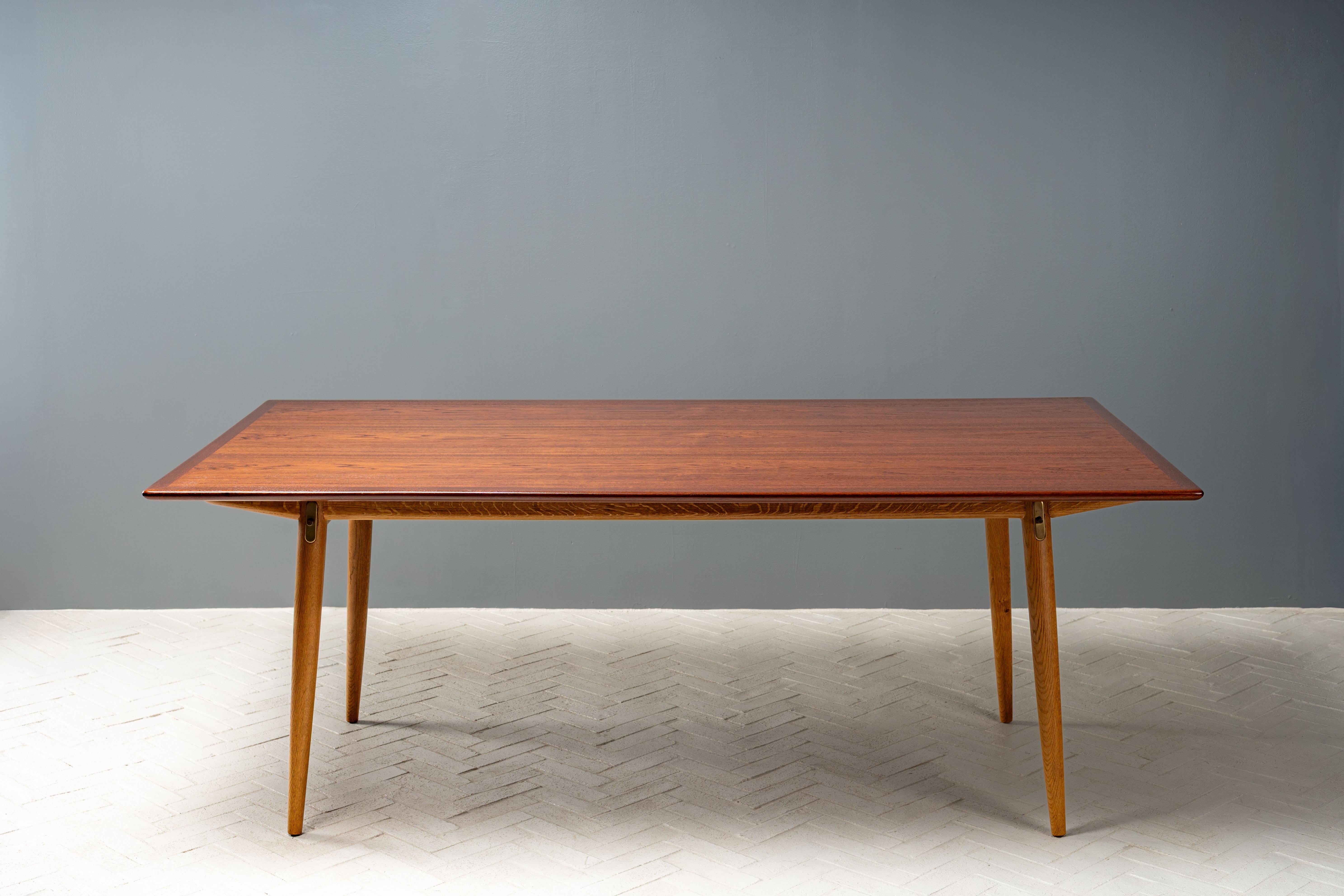 Danimarca, circa anni '50. Un tavolo da pranzo JH-570 di Johannes Wegner per Hansen, molto raro e molto ambito. Presenta un generoso piano rettangolare in teak con un elegante labbro smussato, sostenuto da una base scultorea in rovere massiccio,