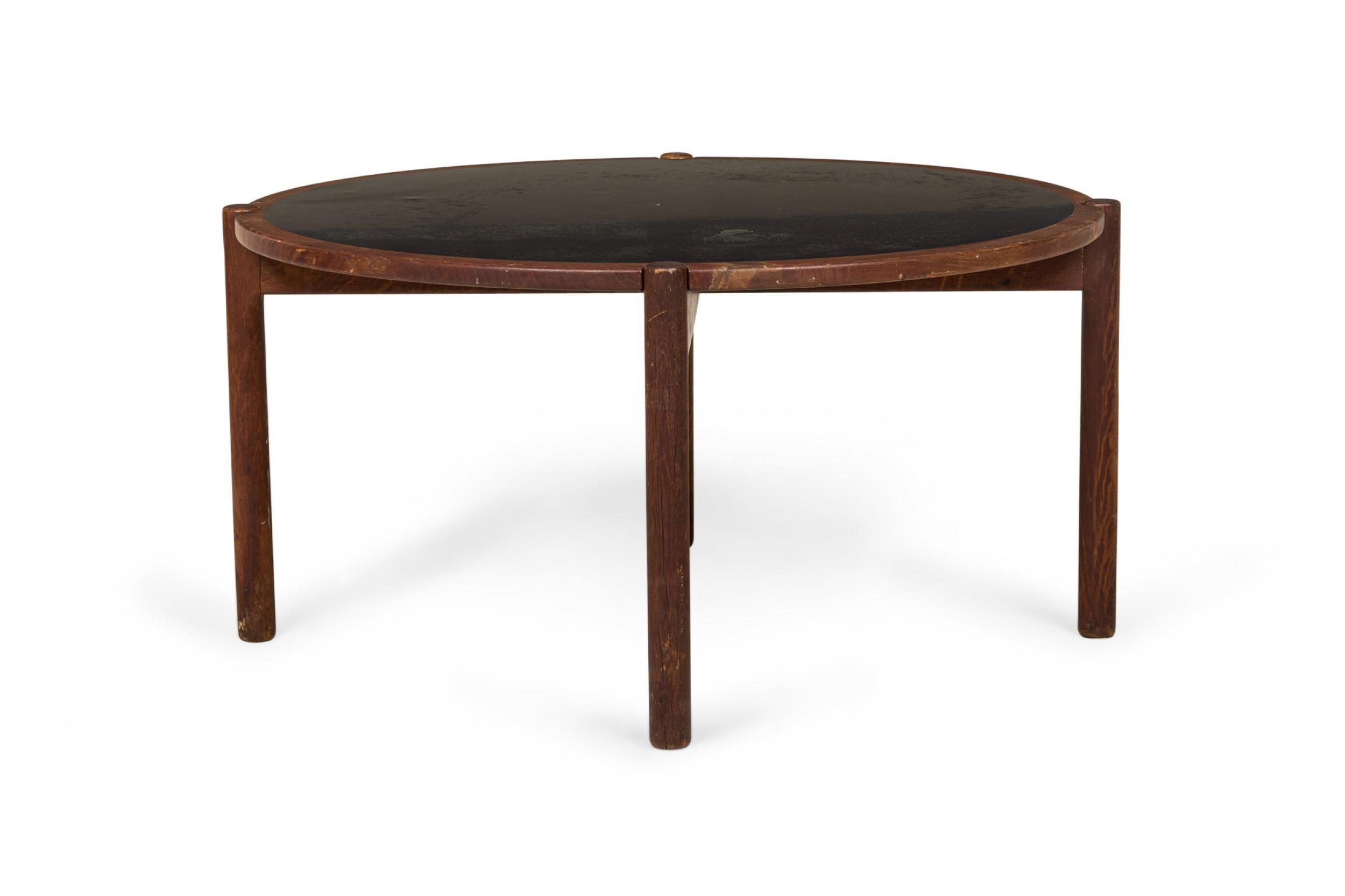 Danish mid-century coffee / cocktail table with a circular reversible top with a black laminate surface on one side and a solid teak surface on the reverse, resting on four round teak legs. (Hans Wegner / Johannes Hansen).