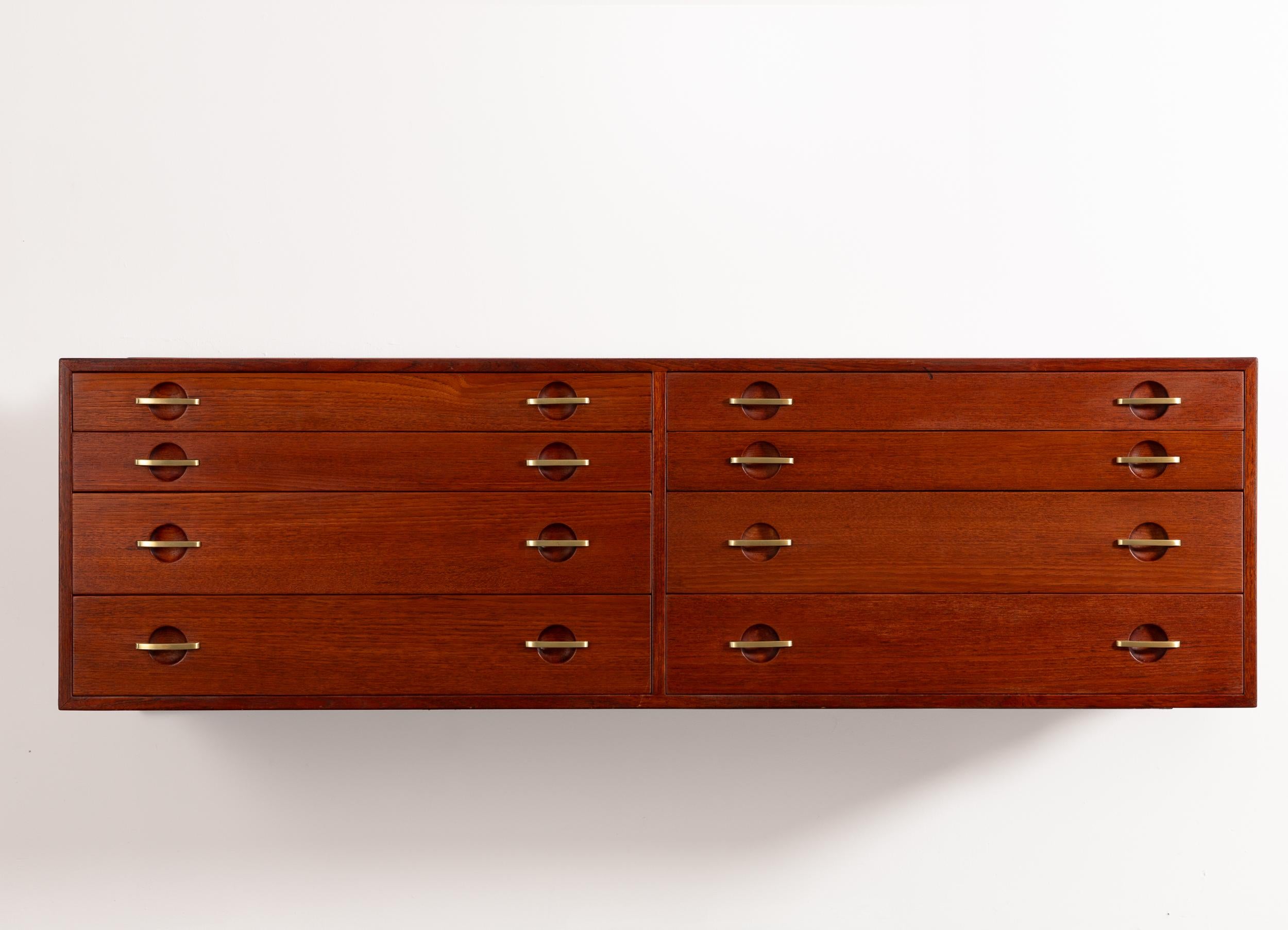 Armadio o cassapanca galleggiante di Hans J. Wegner, disegnato per Johannes Hansen. Costruito in teak antico, questo mobile è dotato di due banchi di cassetti, per un totale di otto, che offrono ampio spazio e funzionalità. I frontali dei cassetti
