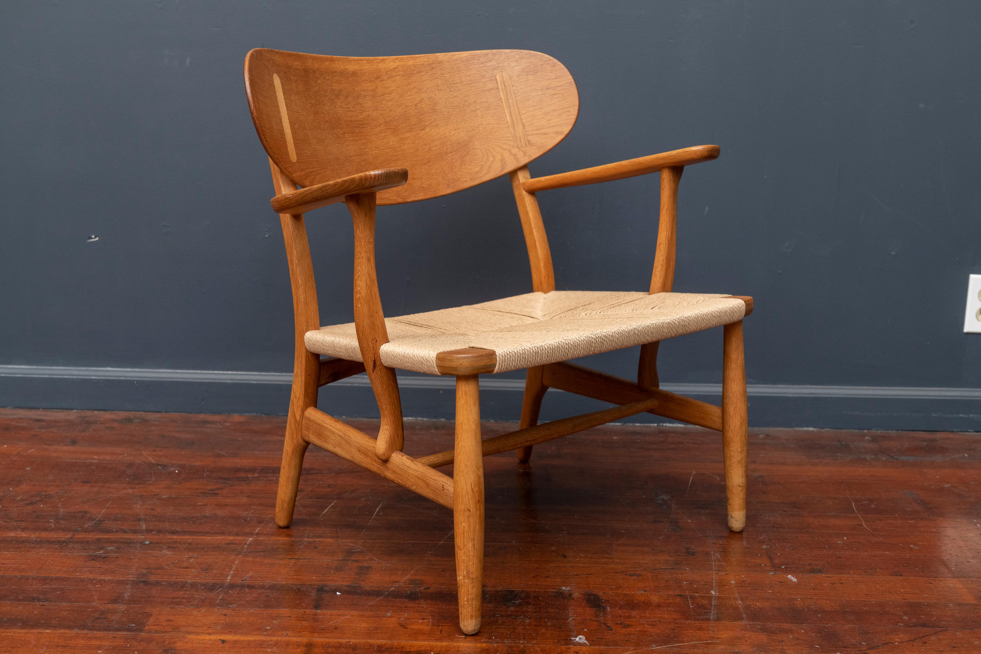Hans Wegner design teak and oak lounge chair, model CH-22 for Carl Hanson & Son, Denmark. Excellent structural condition with original finish and a new woven seat.