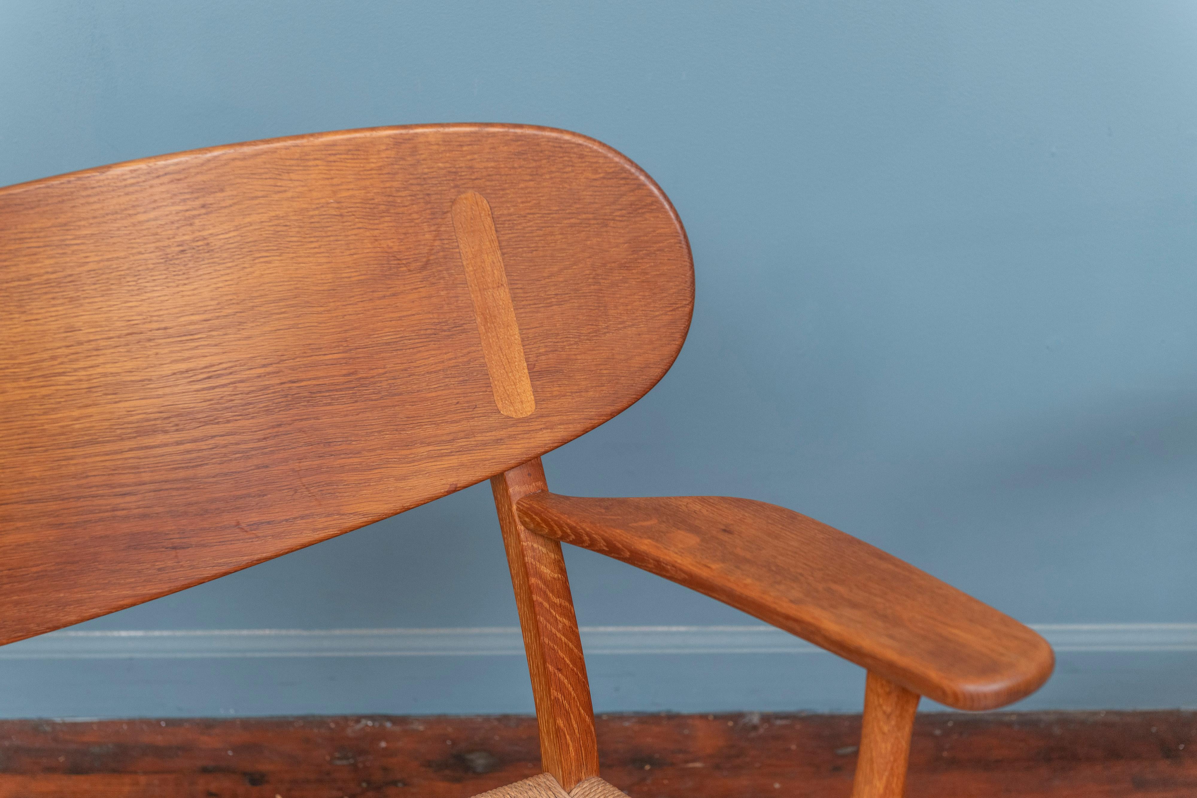 Hans J. Wegner entwirft Loungesessel für Carl Hanson & Son, Modell CH-22 Dänemark. Ein originales Paar Stühle aus Eiche mit originalen Pappsitzen in gutem Originalzustand mit altersgemäßer Patina. Diese ikonischen Beispiele des modernen