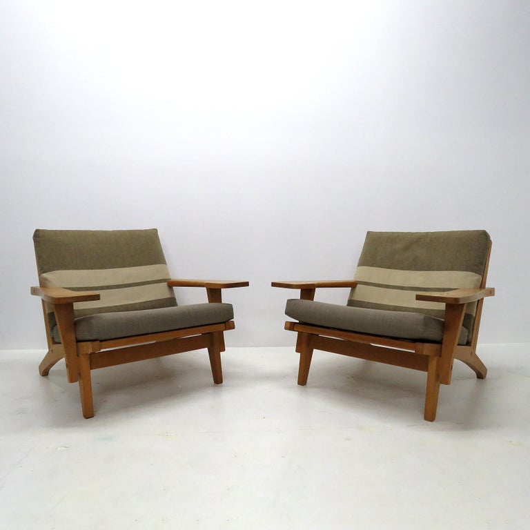 Wonderful large-scale armchairs designed by Hans Wegner with solid oak frame and original cushions in beige/greenish striped wool, produced by GETAMA in 1969, model GE 370, original makers mark to underside.