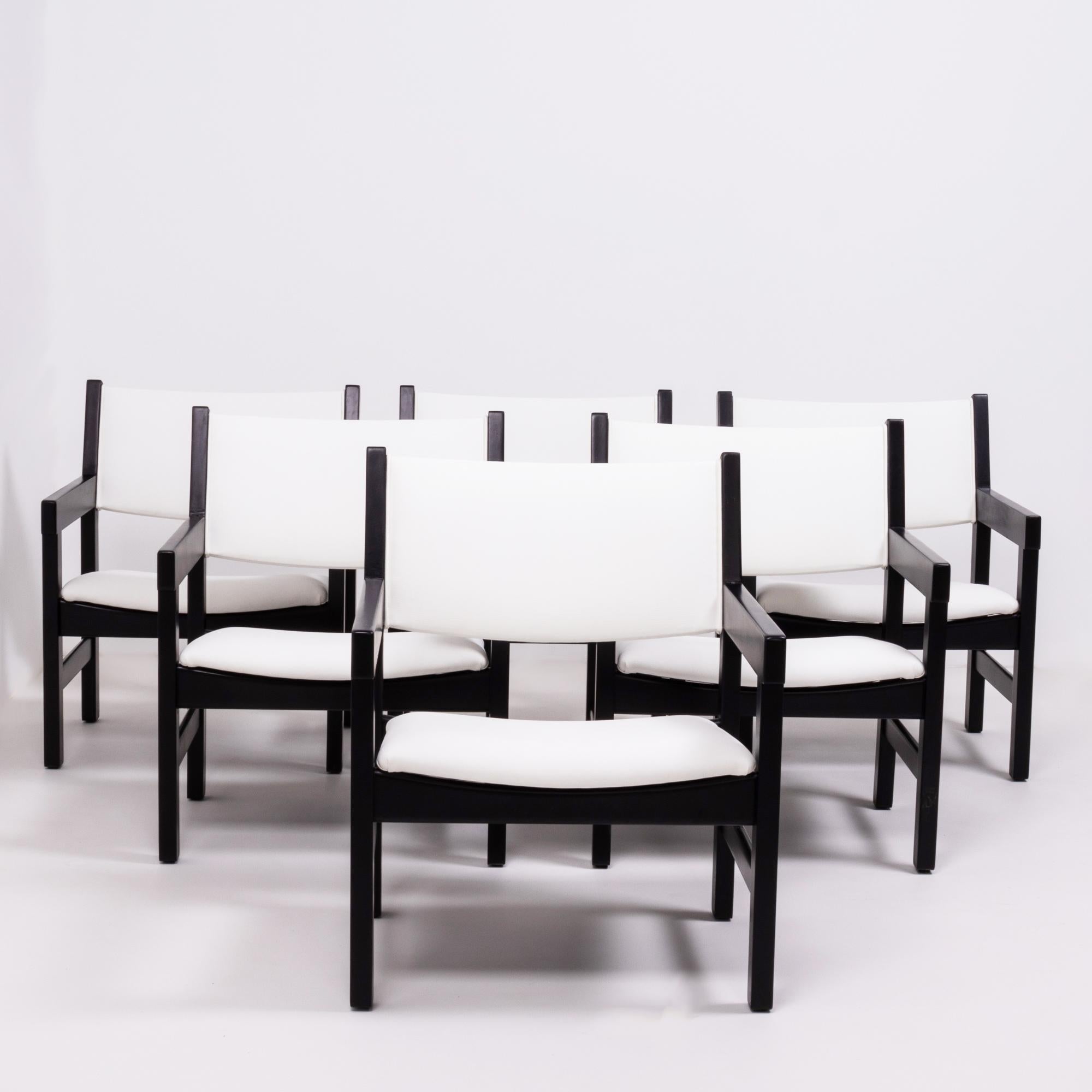 Designed by Hans J. Wegner for GETAMA, this set of six GE 151 chairs are a Classic example of Mid-Century Modern design.

Featuring angular black painted beechwood frames and arms, the newly restored chairs have padded seats and backrests which