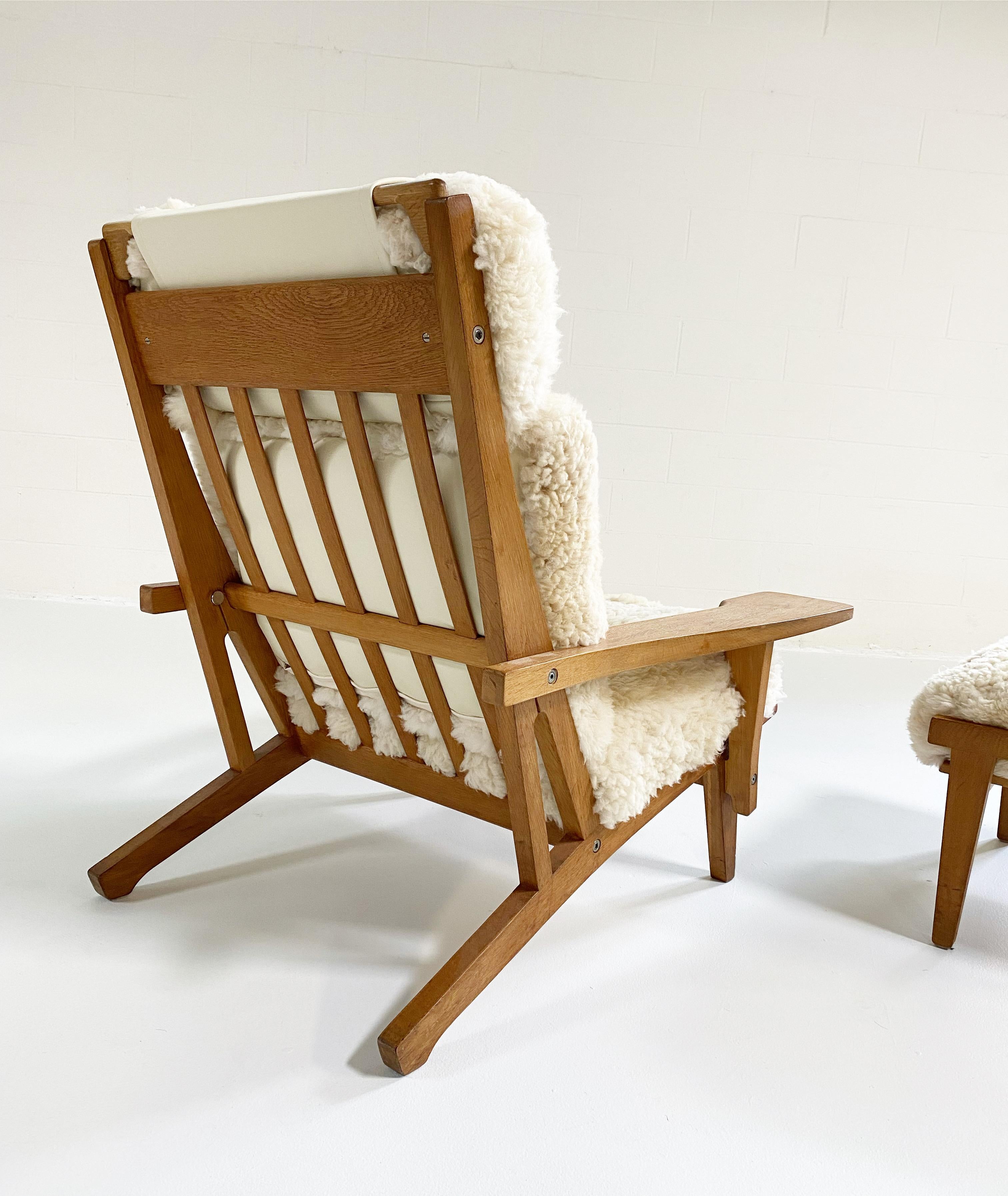 With gorgeous patinaed oak, custom California sheepskin cushions, and a finishing touch of beautiful ivory leather, this Hans Wegner lounge and ottoman set is incredible. The Model GE 375 Chair is nicknamed the 