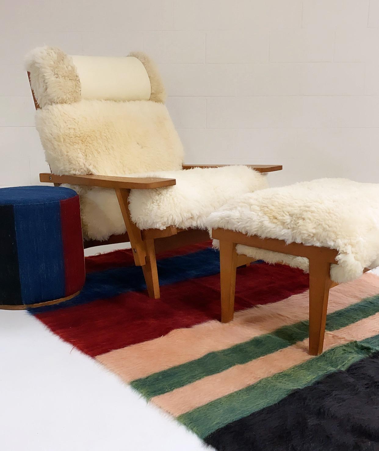 With gorgeous patinaed oak, custom California sheepskin cushions, and a finishing touch of beautiful ivory leather, this Hans Wegner lounge and ottoman set is incredible. The Model GE 375 Chair is nicknamed the 