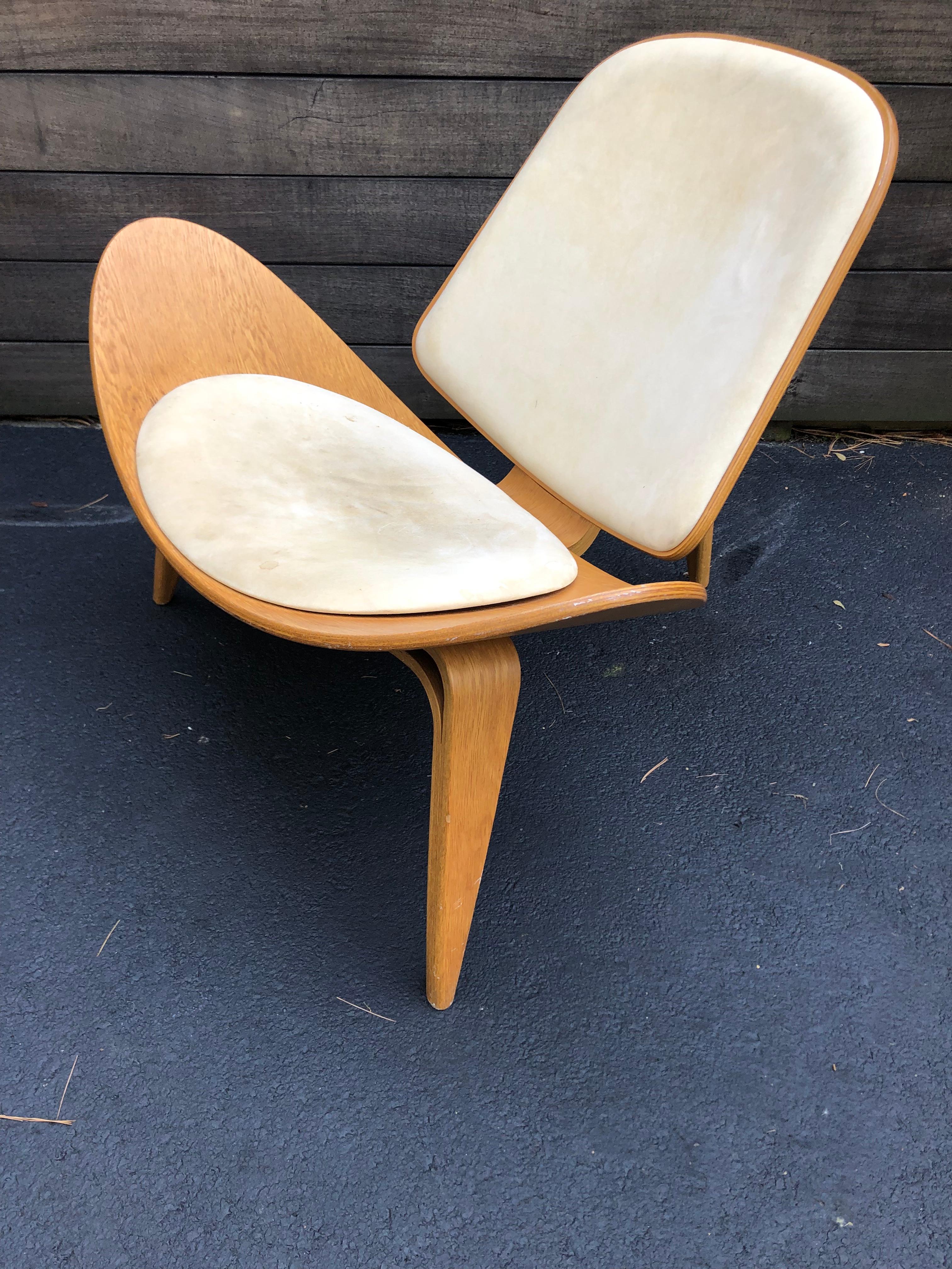 Hans Wegner molded walnut plywood shell chair model CH07. Design dates to 1963, reintroduced in the late 1990's. This model dates to 2006 and leather shows appropriate wear. Would be easy enough to recover seat and back. Surprisingly stable and