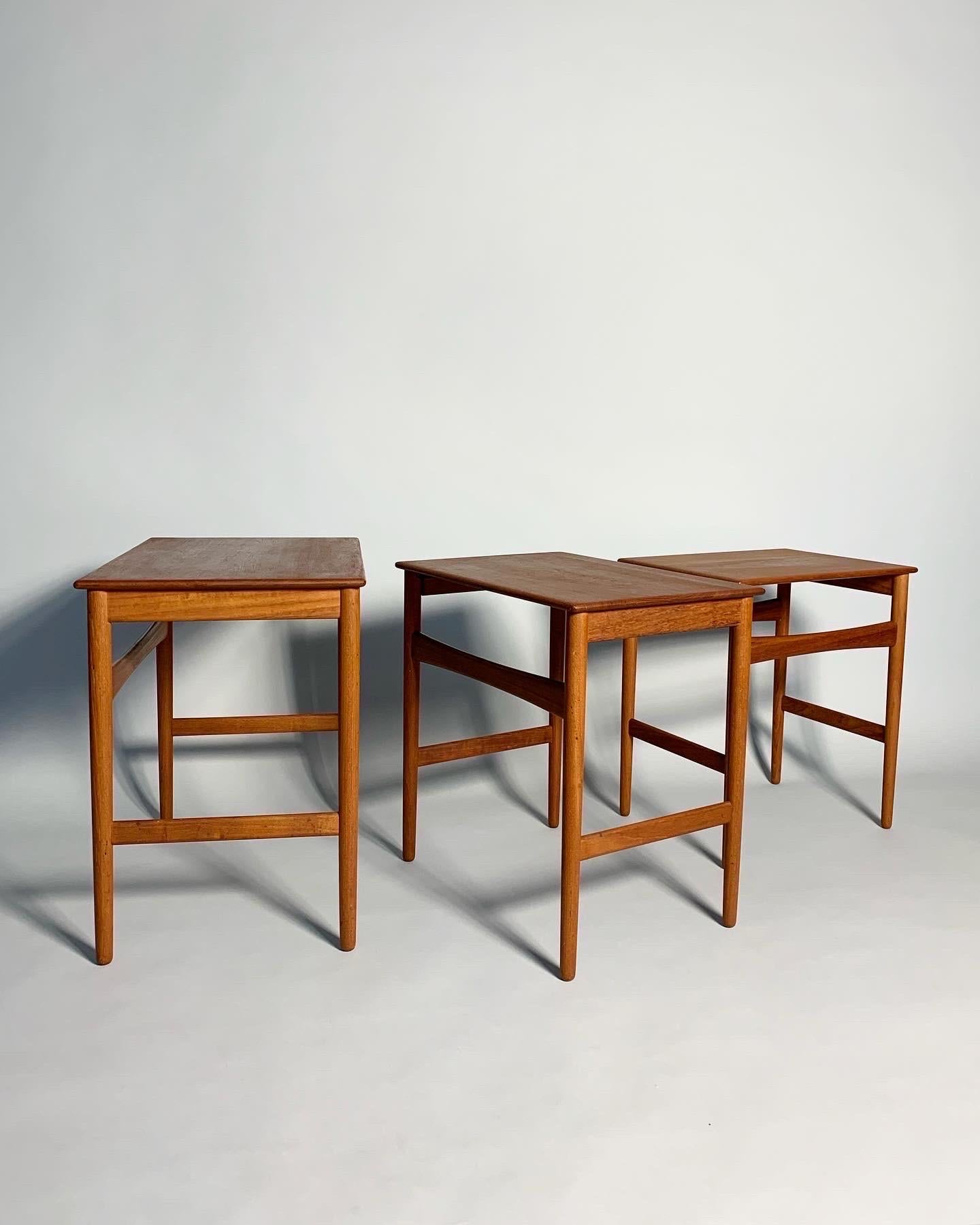 Probably the most beautiful of all Danish nesting tables are these Hans Wegner AT-40, which he designed for Andreas Tuck in Denmark in the 1950s.

The solid teak tops have been refinished, only minimal wear visible. One of the legs was broken and