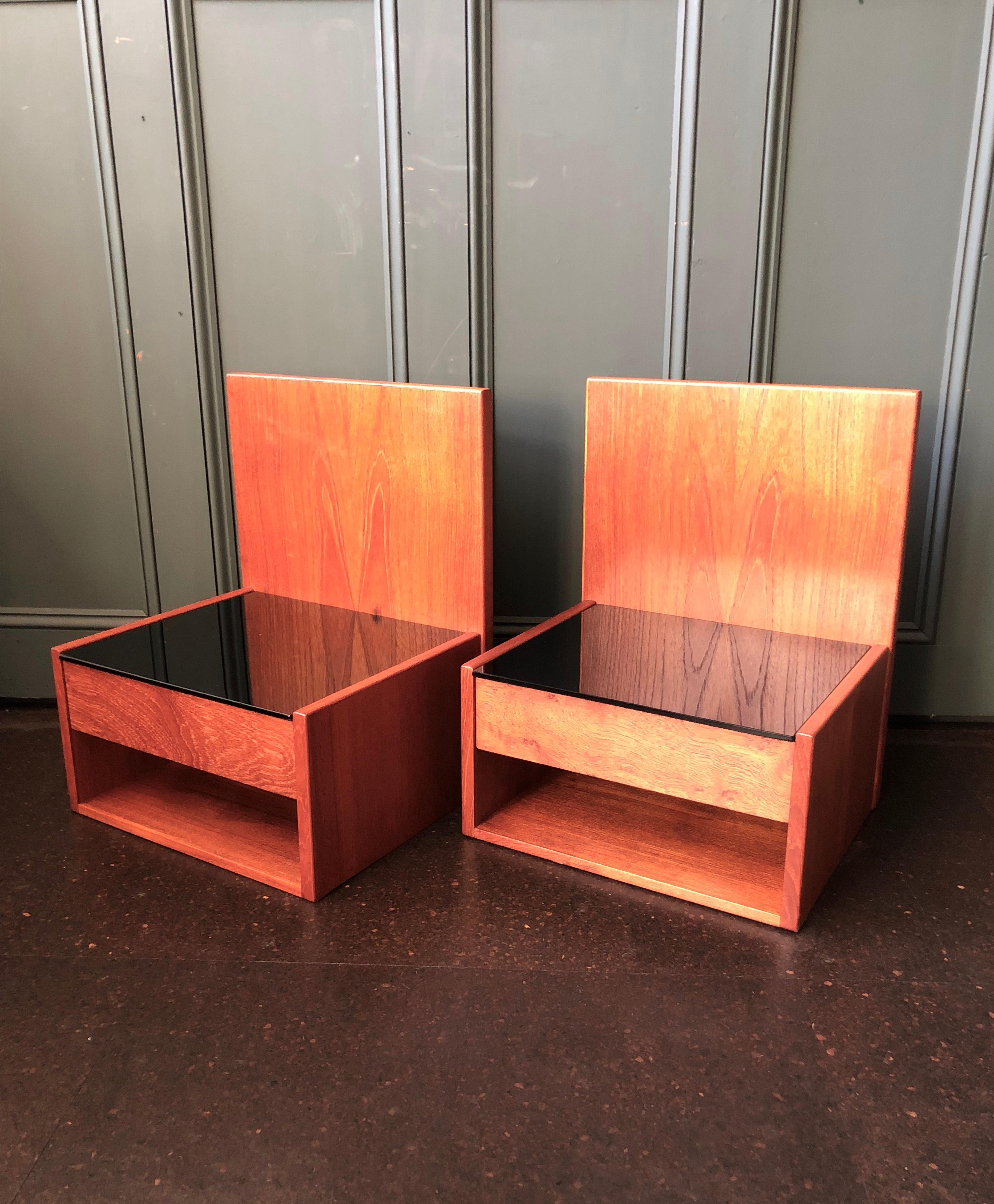 A pair of original Danish midcentury 1960s Hans Wegner nightstands. Constructed from teak with a black glass surface. Manufactured by GETAMA, Denmark. Beautifully modernist design from the Danish master. These are designed to be ‘floating’