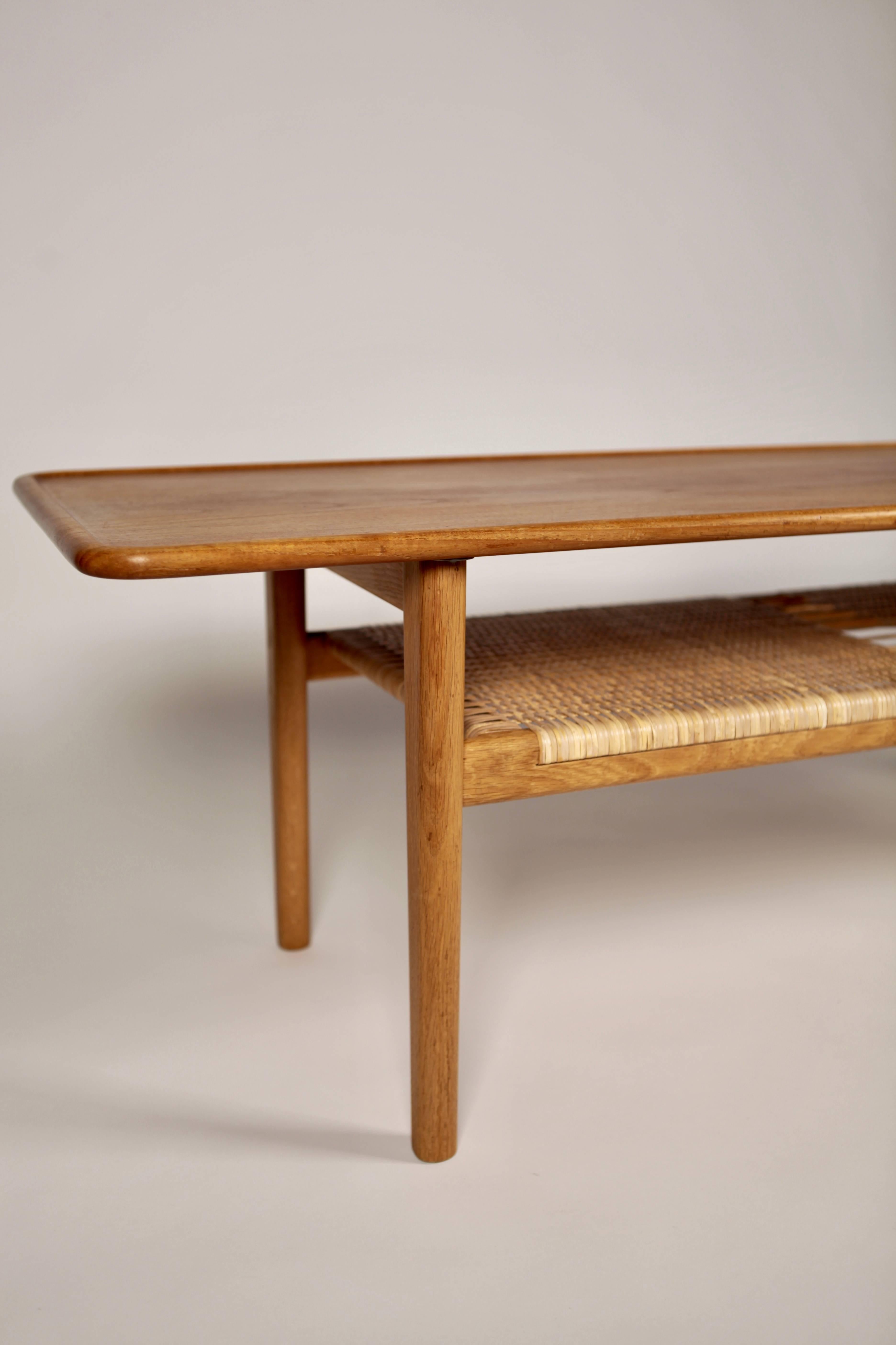 Coffee table AT-10, designed by Hans Wegner and manufactured by cabinetmaker Andreas Tuck in Denmark, 1950s.
Excellent condition.
Teak top, construction in oak and cane.
Signed to the underside.