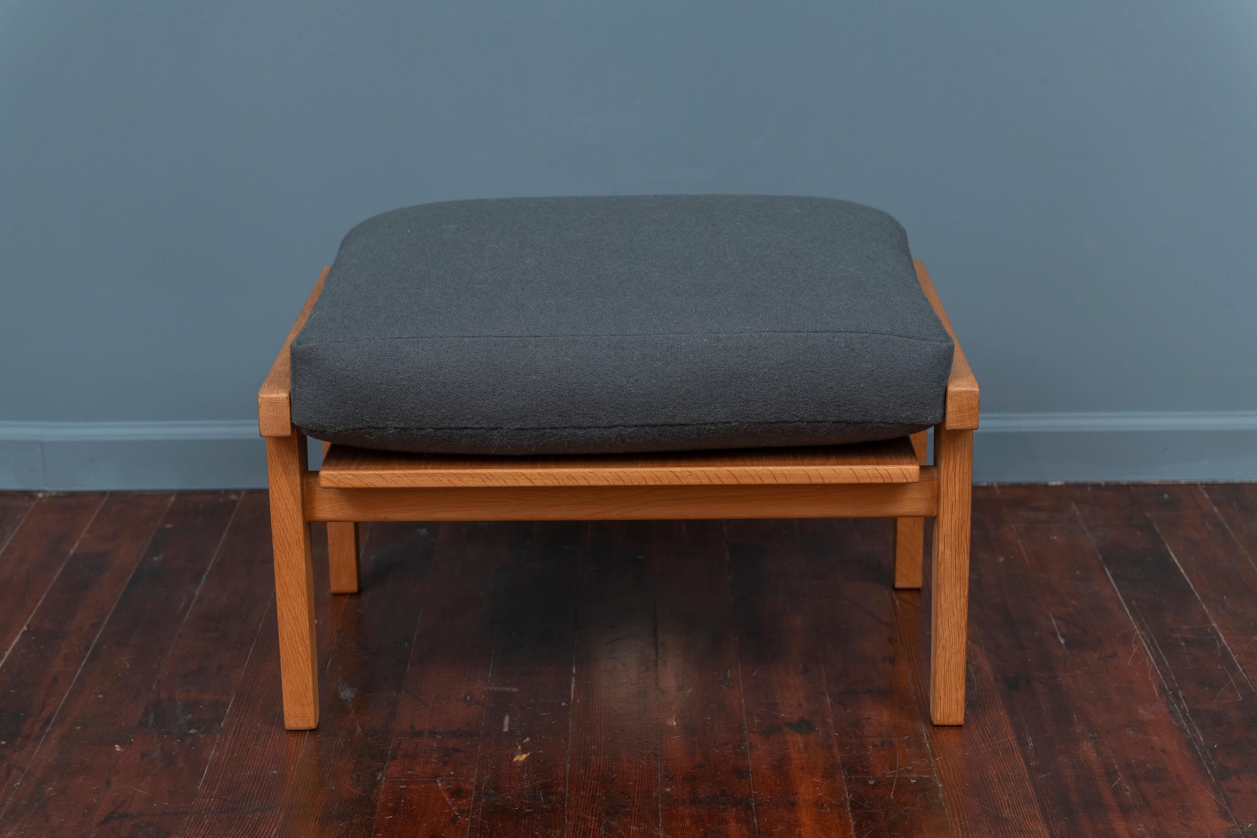 Hans Wegner design ottoman for GETAMA, Denmark. Model GE 290 solid oak frame in very good original condition with a newly upholstered wool cushion, signed.