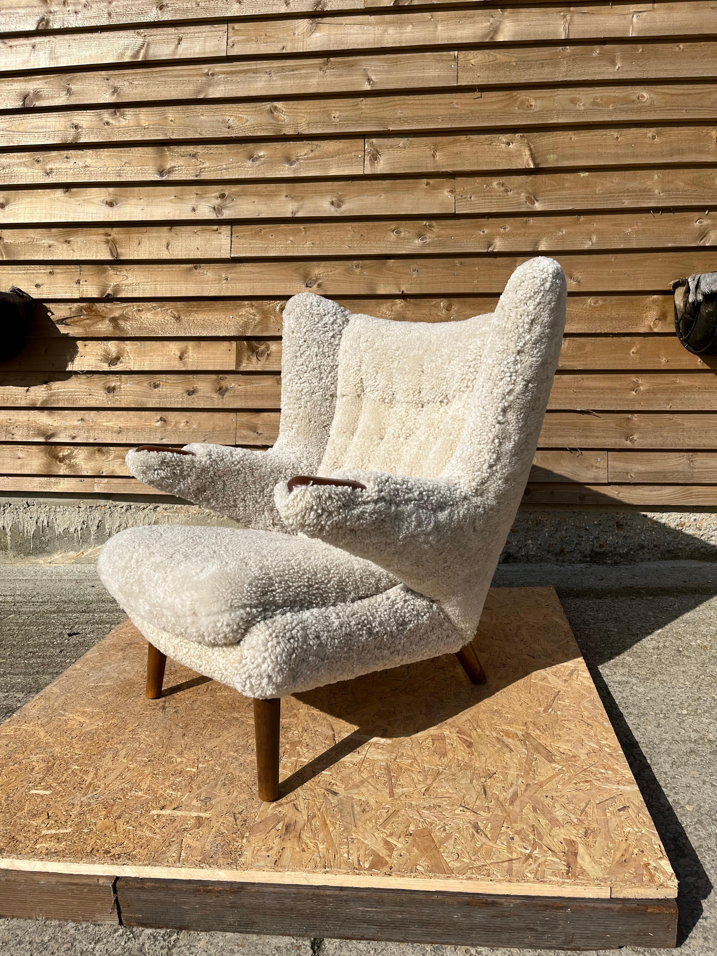 “Papa bear chair”. Easy chair with legs of beech, “nails” of teak. Seat, sides and button fitted back upholstered with natural colour lambs wool hide. Model AP 19. Designed 1951.  Manufactured by AP Stolen. 

Reupholstered in Denmark by the best in
