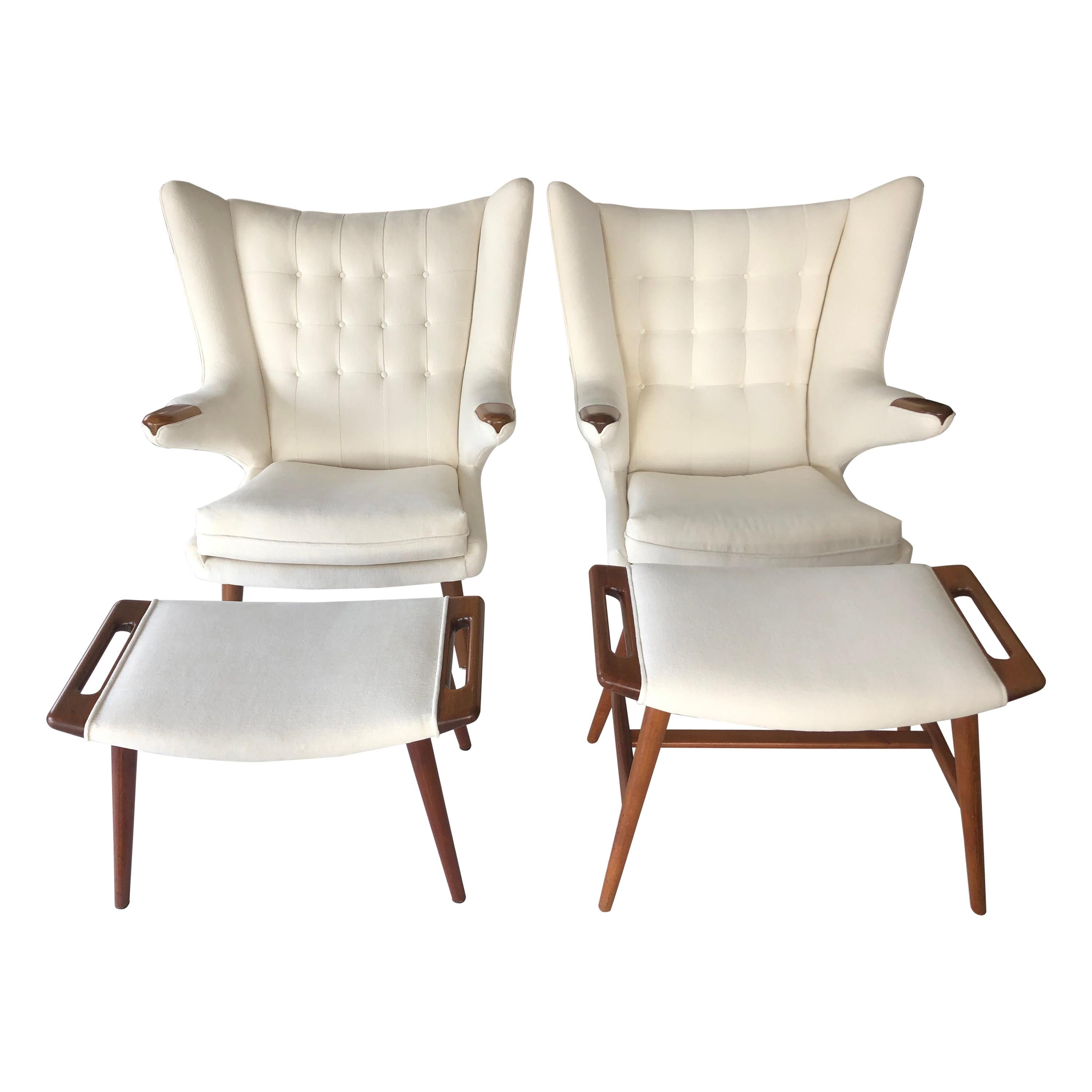 Pair of papa bear chairs with matching ottoman stools by Hans Wegner, Denmark, 1950s. Upholstered in off-white fabric, with stained teak. The price includes one chair and one ottoman. Can be sold individually or as a pair.