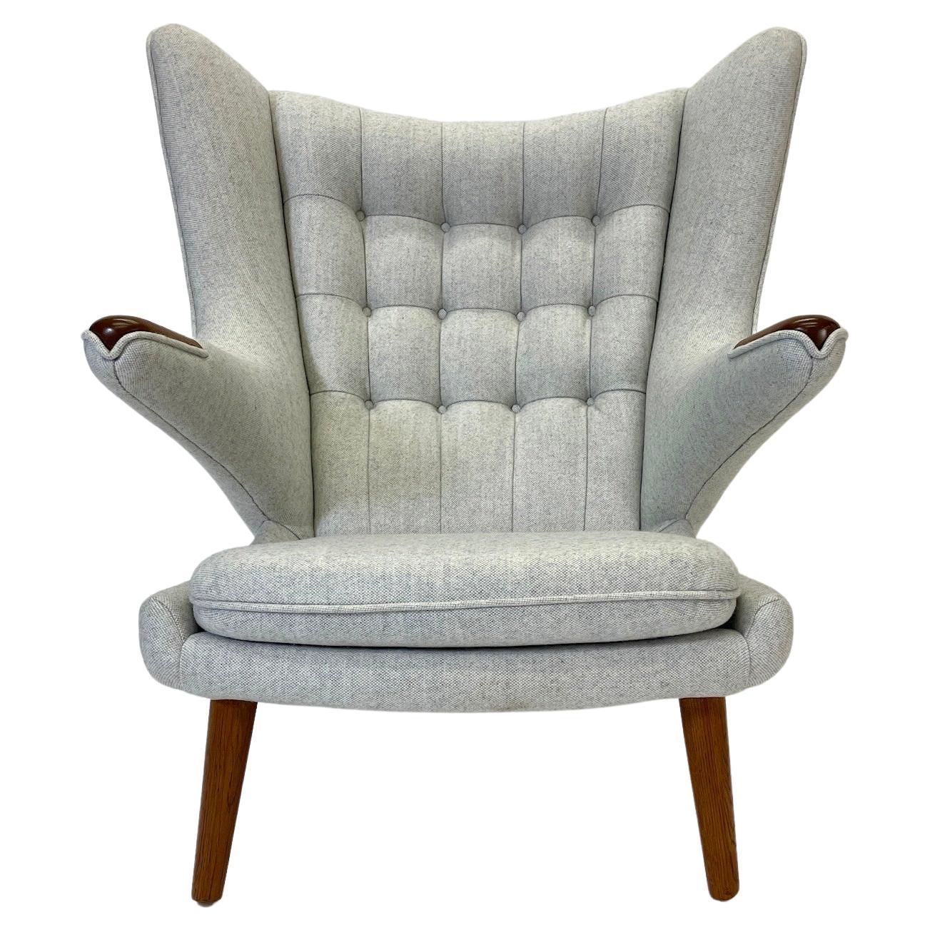 La chaise Papa Ours  est une pièce absolument étonnante.  AP-29. Une chaise vraiment emblématique, nouvellement tapissée dans la plus belle laine grise de Maharam. La chaise est dotée de magnifiques pieds en chêne et de pattes en teck.

Bien
