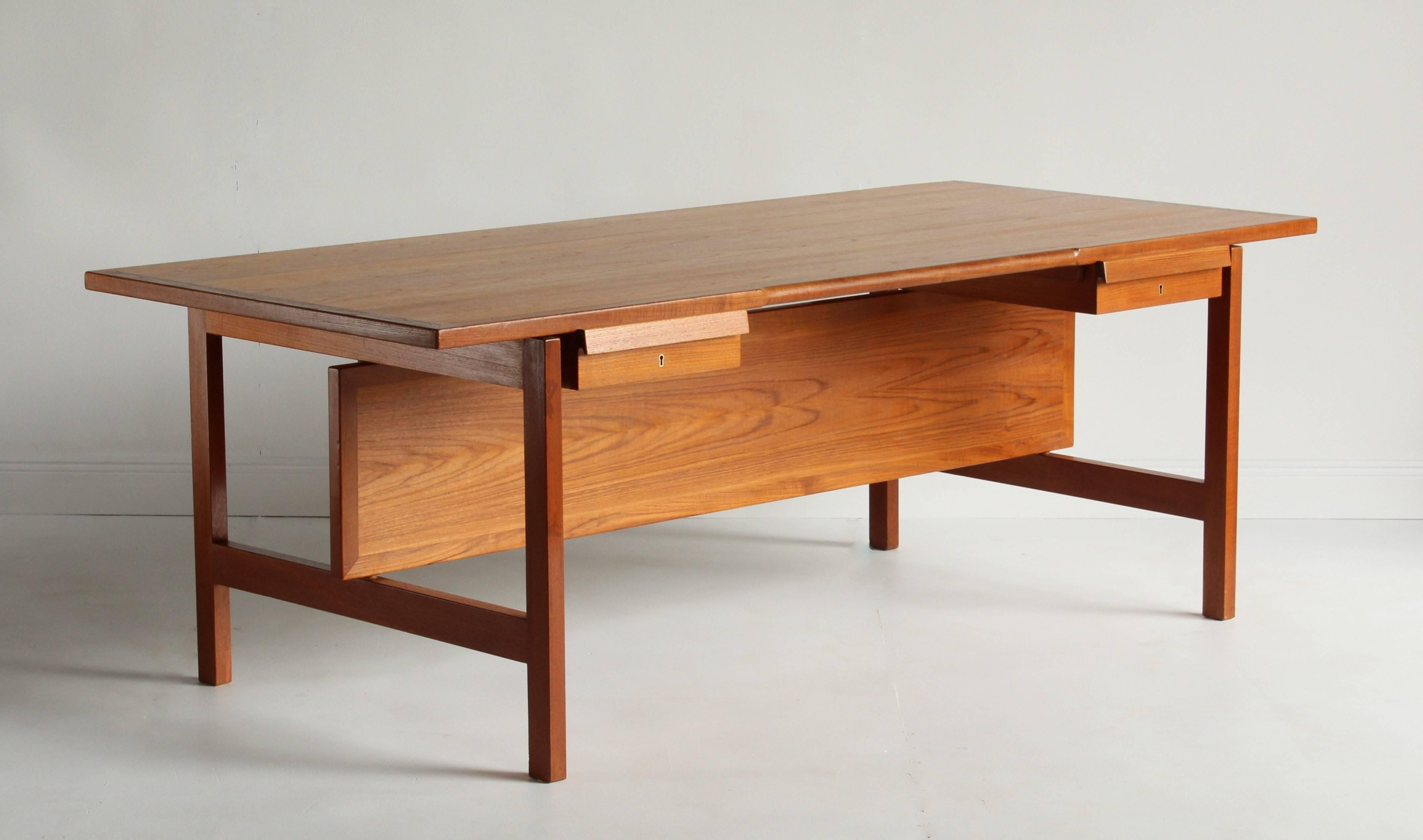 A large teak desk by Danish designer Hans Wegner, produced by Andreas Tuck. The present example is a rare variation of the 