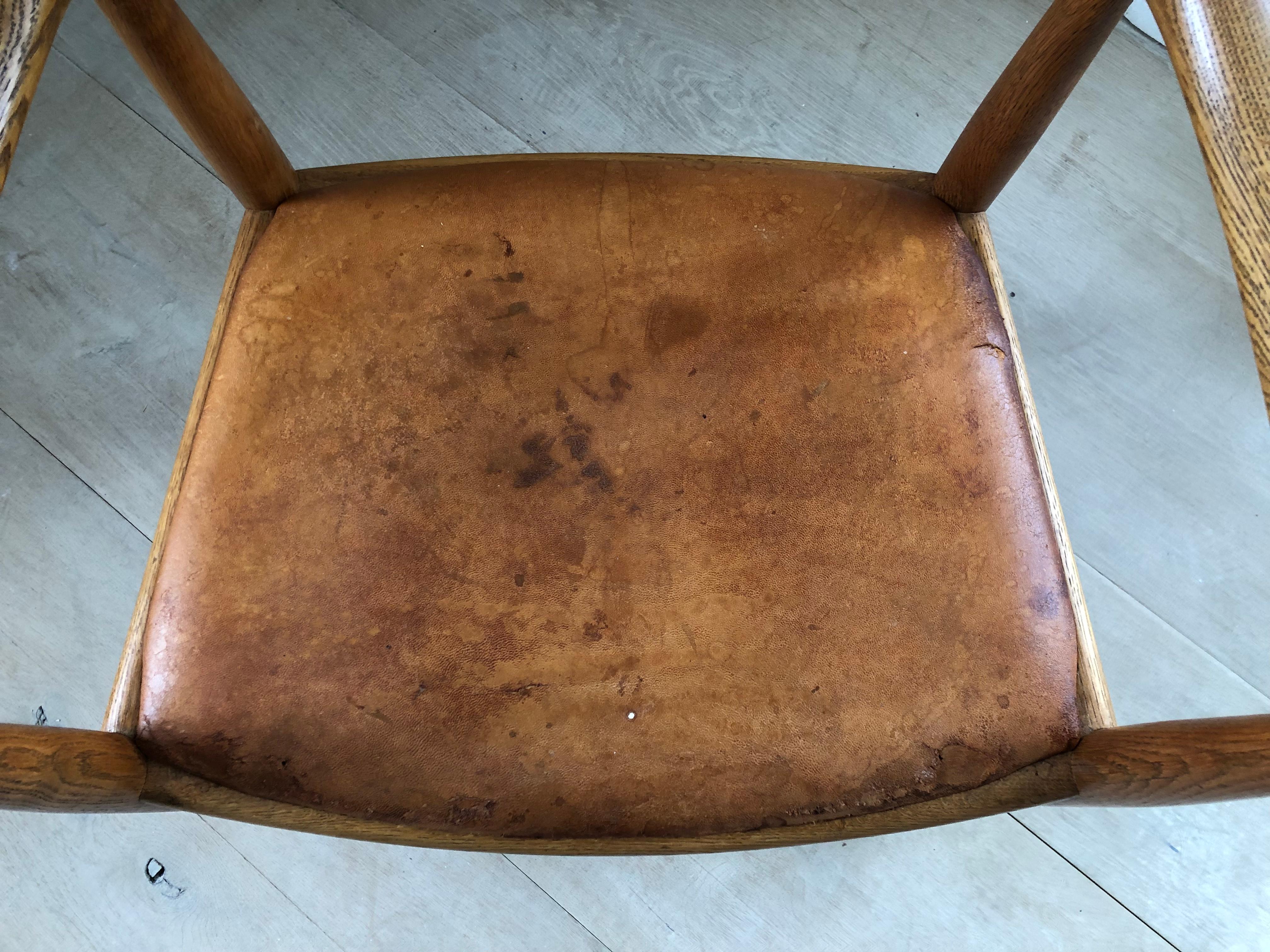 Cette chaise est un excellent exemple vintage de la chaise ronde de Wegner en chêne. Le Label indique qu'il a été fabriqué avant 1970. 

Le cuir du siège présente des traces de décollement, d'usure et de déchirure à la surface, comme le montrent