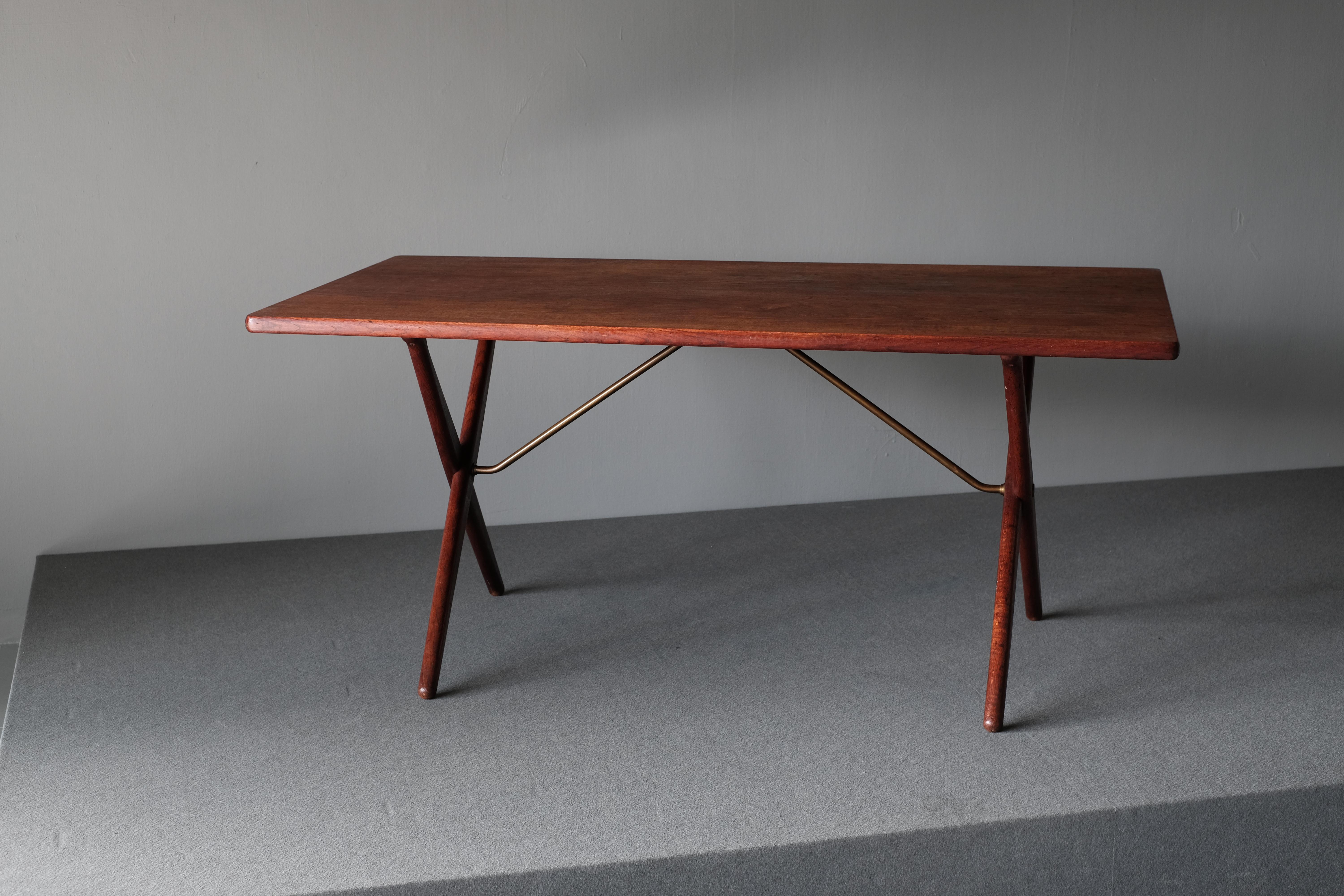 Fantastic table, AT-303 designed in 1955 by Hans Wegner and manufactured by Andreas Tuck. It is also known as the “Saw Horse Table”. The table is in teak with oak legs. The tabletop is supported by brushed brass tubular supports. As with all of