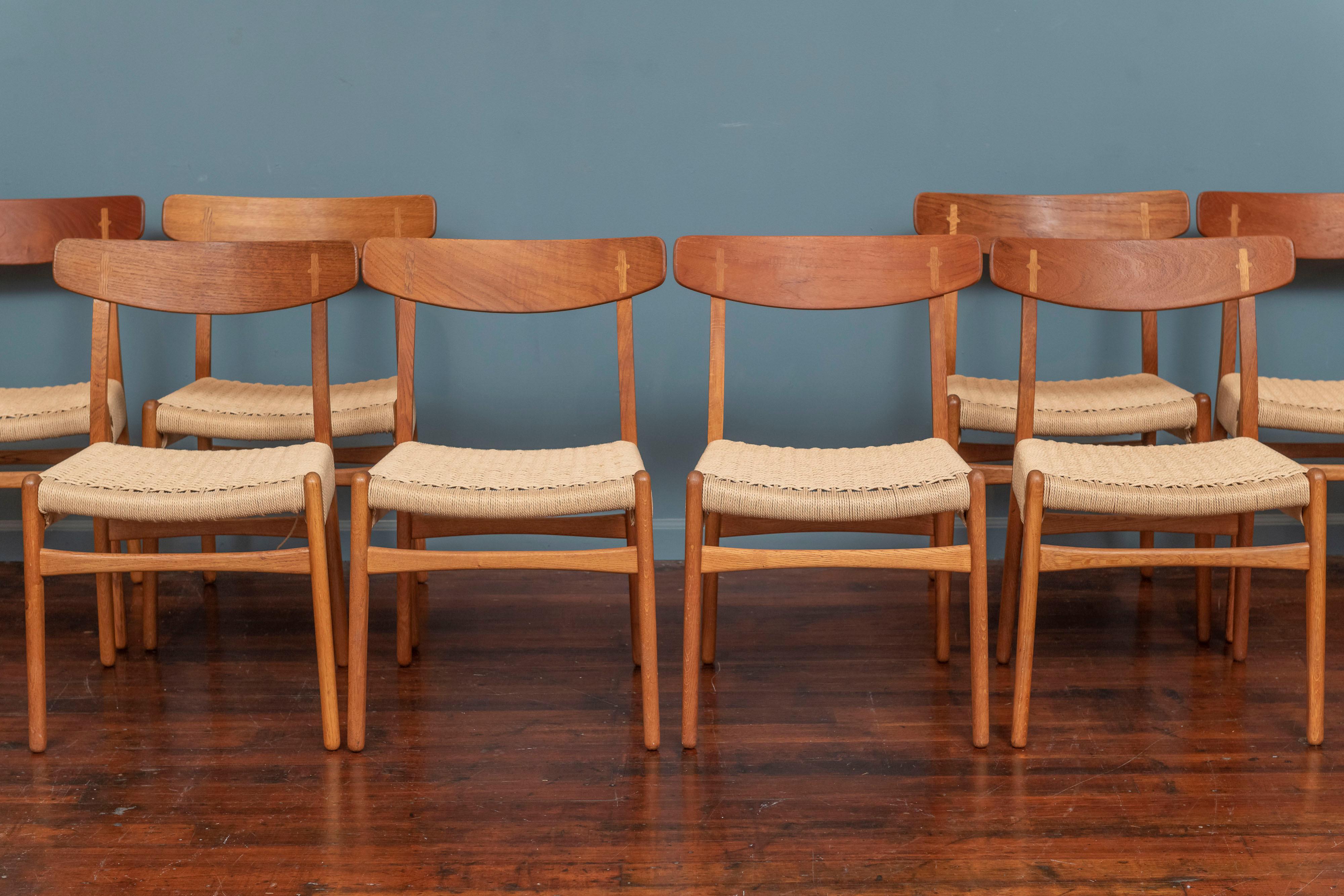 Hans Wegner design set of eight dining chairs model CH-23 for Carl Hanson & Son, Denmark.
 In very good original condition with newer replaced danish cord woven seats without stains or breaks.One chair has a professionally repaired broken leg that