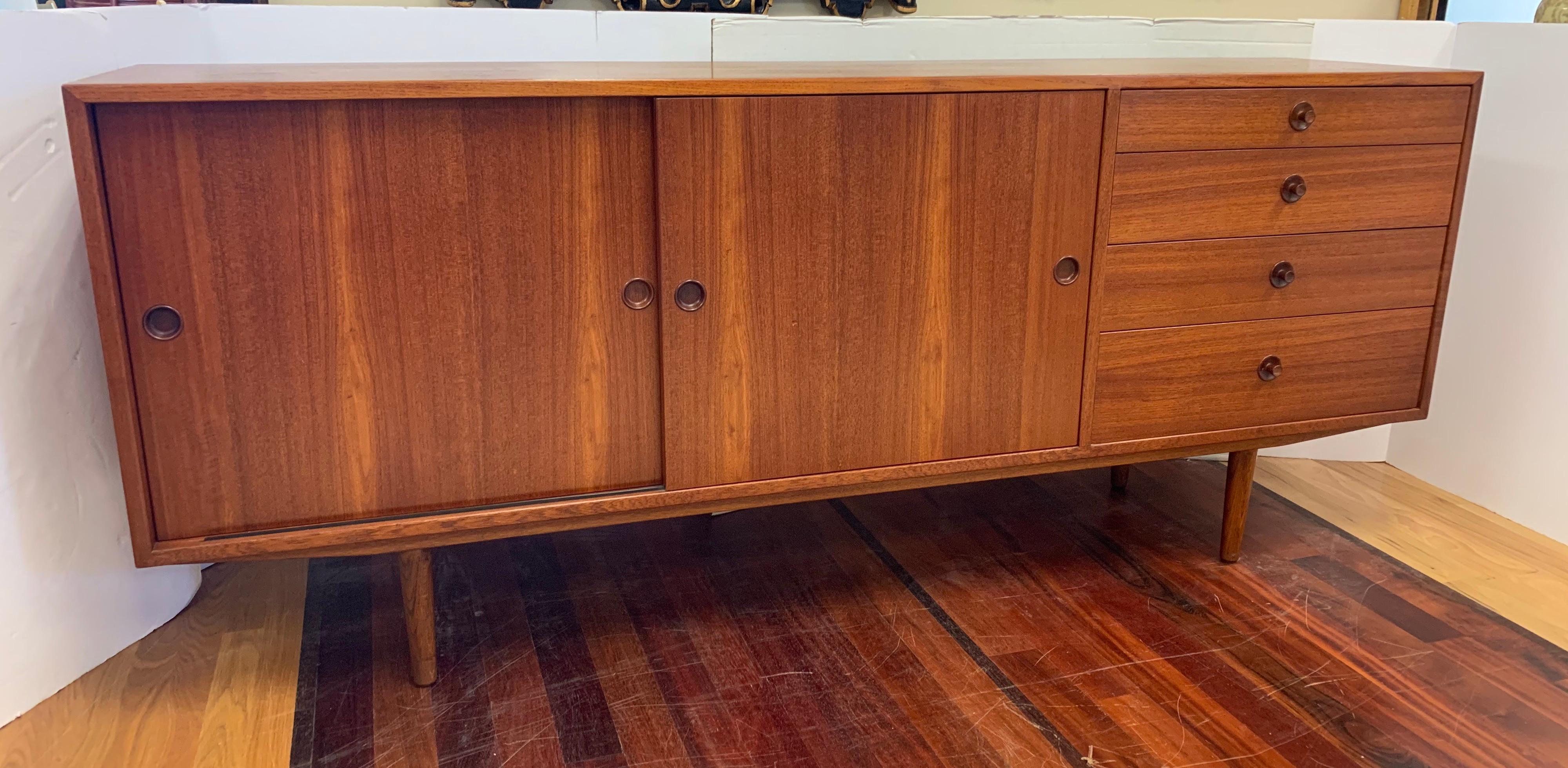 Signed Danish modern Hans Wegner teak sideboard. With all hallmarks on back circa 1950s. Features clean lines, great scale and an iconic design. Versatile piece can be used as a sideboard, buffet or entertainment console. See all pictures attached