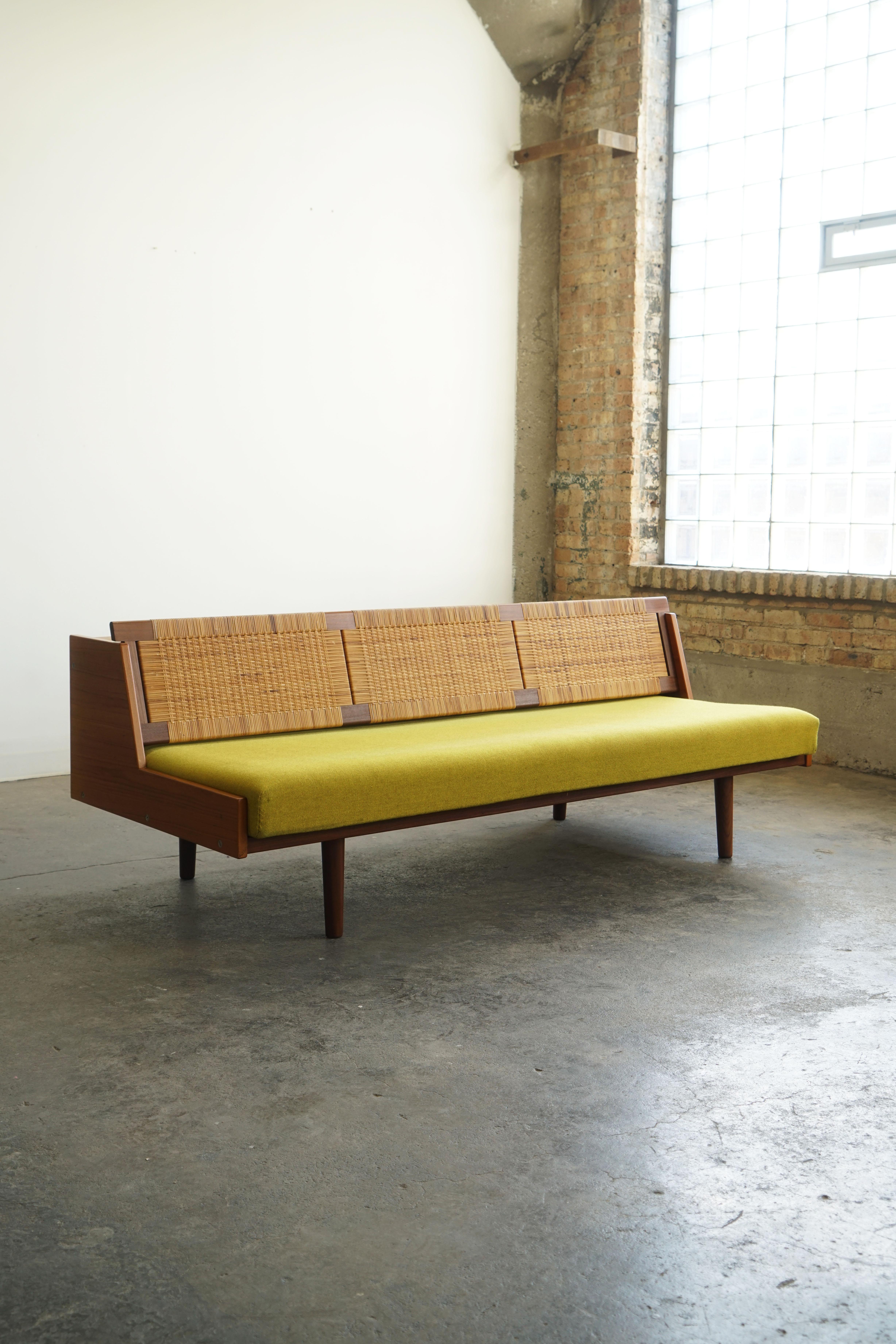 Hans J. Wegner for Getama, Daybed model GE 7
Denmark, circa 1965.
Teak, painted wood, upholstery, caning.

This really cool convertible daybed / sofa, designed by Hans J Wegner, features a 
woven cane back seat which opens up reveals a hidden space