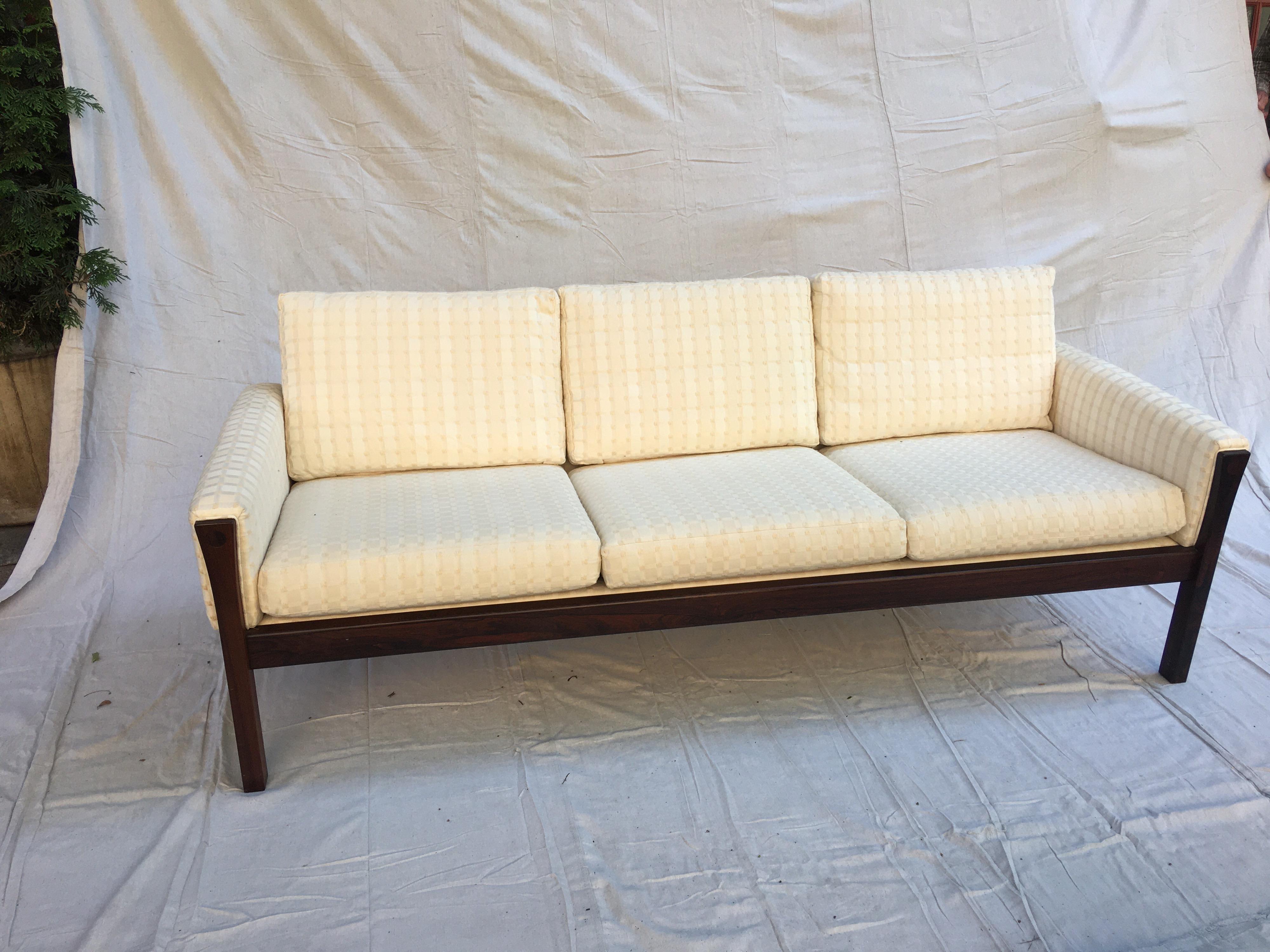 Hans Wegner soild rosewood sofa. Beautiful understated Sofa. Great size and scale! Nice carved detail to top of legs, circle design cut out front and back. Fabric is very clean, redone maybe 10-15 years ago. Strapping will be replaced if buyer