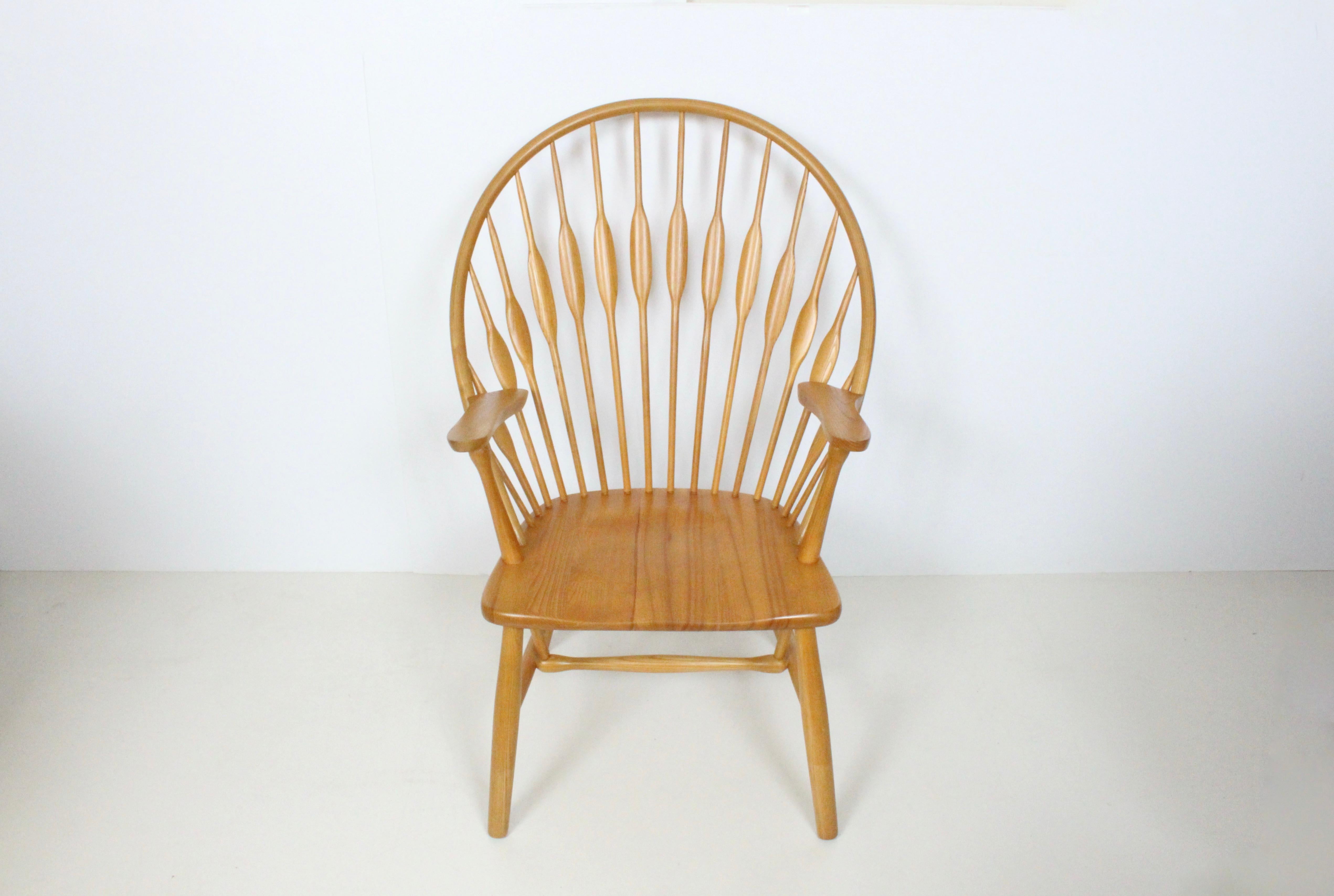Iconic Ash Wishbone arm lounge chair in the style of Hans Wegner, 1970's. Featuring professionally refinished solid framework, smooth plume back, wide solid seat and arms. Classic. Comfortable. Statement seating. Additional shipping options may be
